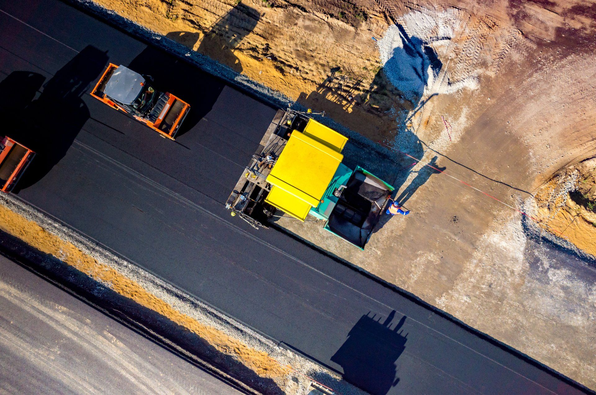 construction workers adding asphalt on the road