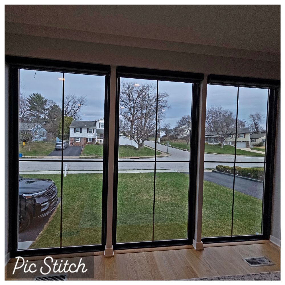 Living room view through large windows of a quiet suburban street and front yards on a cloudy day