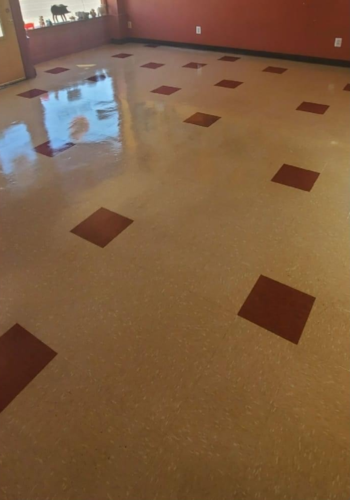 Tan and red checkered flooring in a room with red walls and a window.
