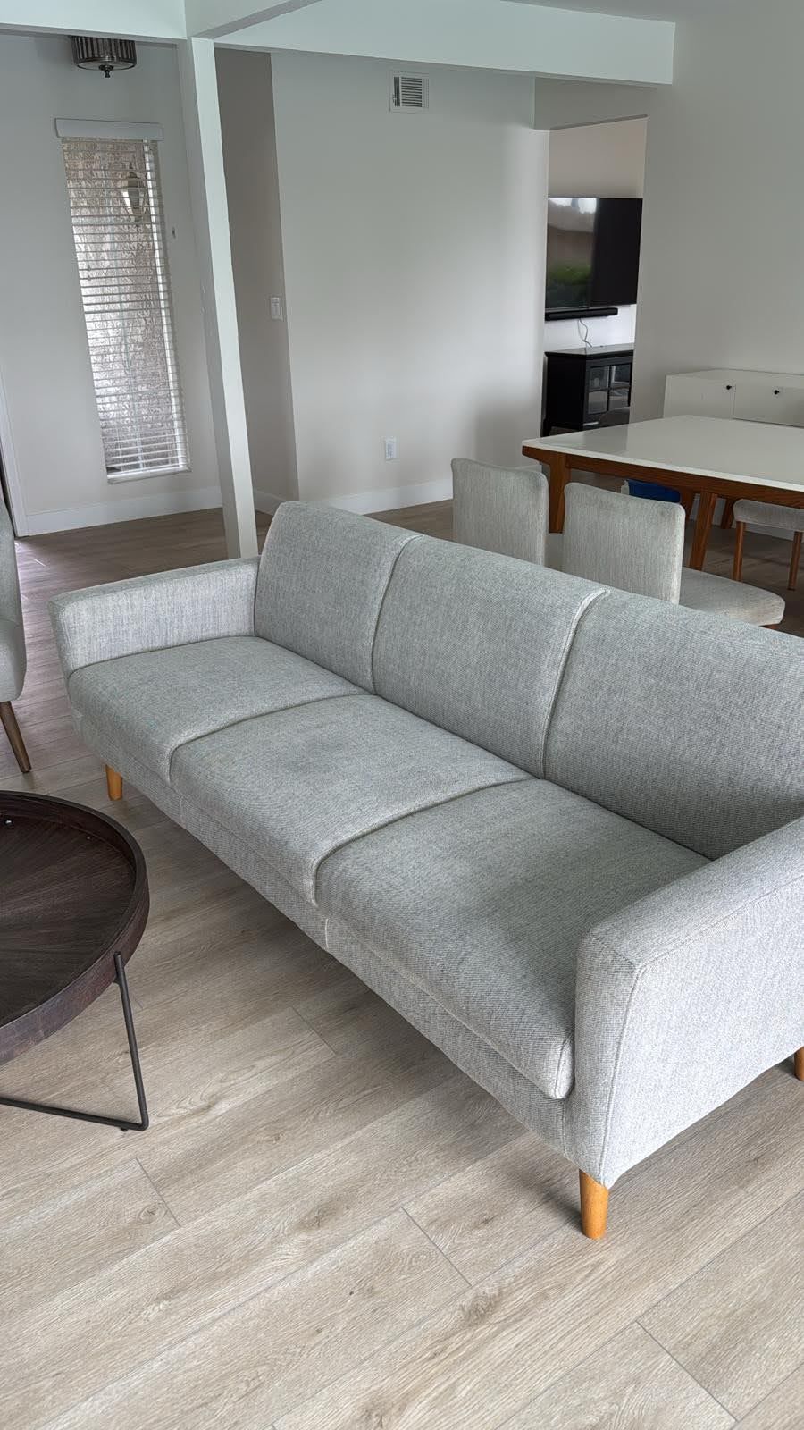 Light gray sofa in a modern living room setting with light wood floors.