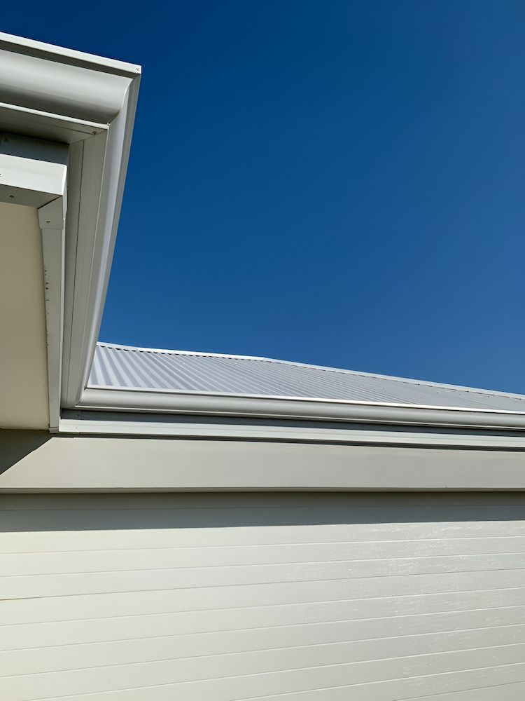 The Roof Of A White House With A Blue Sky — The Gutter Guy NSW in Tarrawanna, NSW