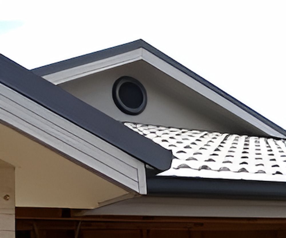 The Roof Of A House Has A Round Window On It — The Gutter Guy NSW in Tarrawanna, NSW