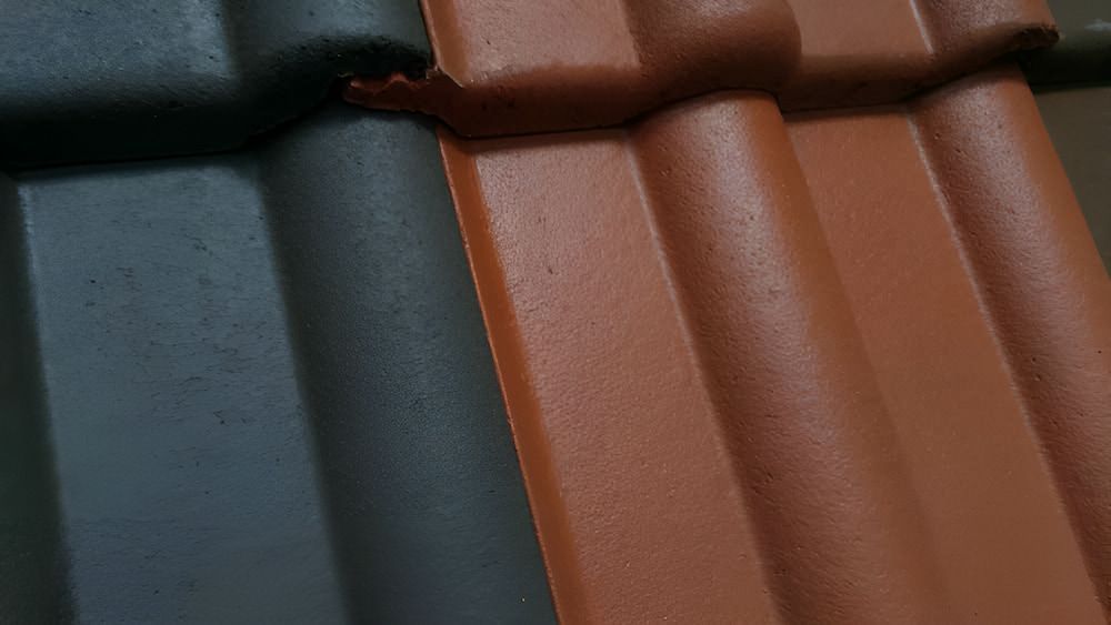 A Black And Red Tile On A Roof — The Gutter Guy NSW in Tarrawanna, NSW