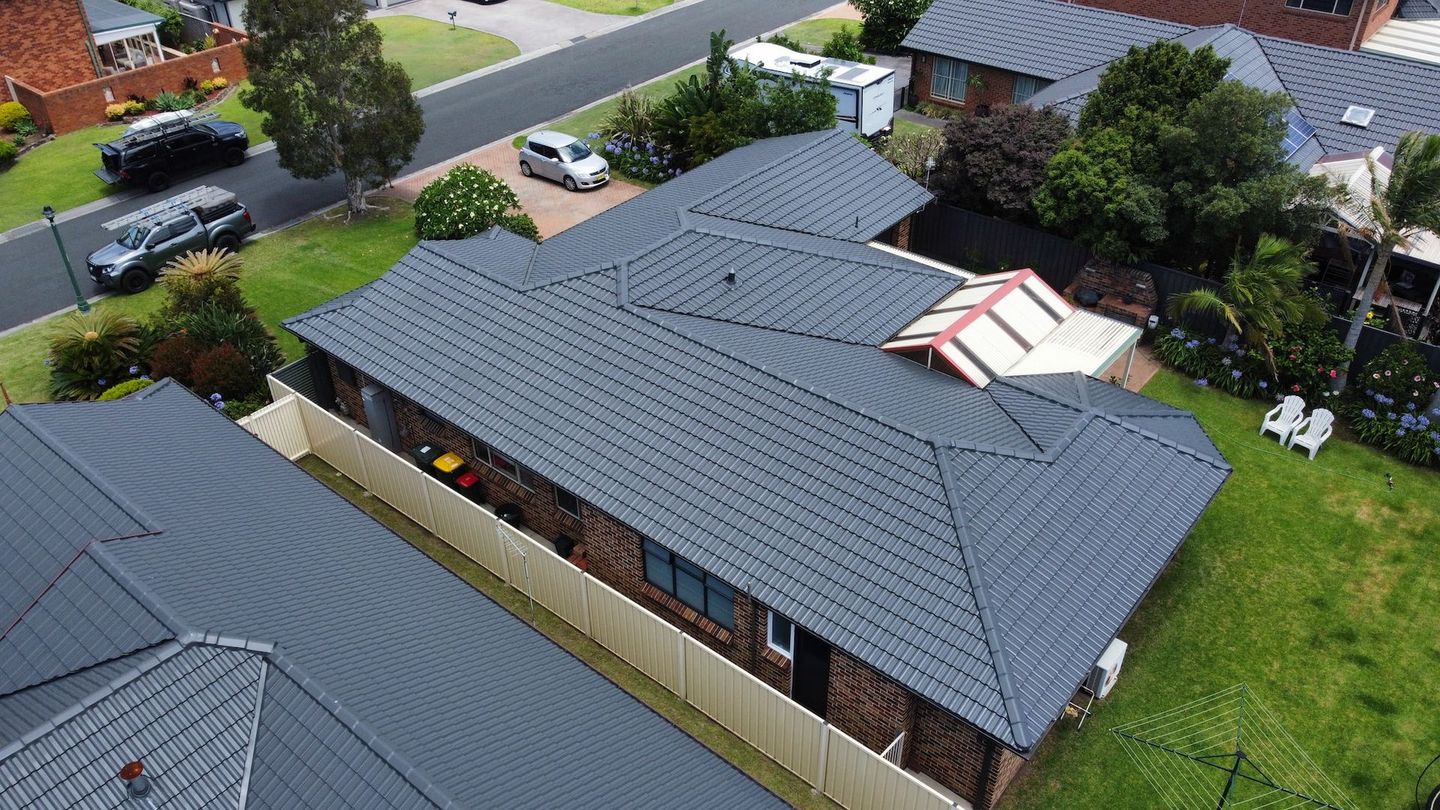 An Aerial View Of A House With A Roof That Is Surrounded By Other Houses And Trees — The Gutter Guy NSW in Tarrawanna, NSW