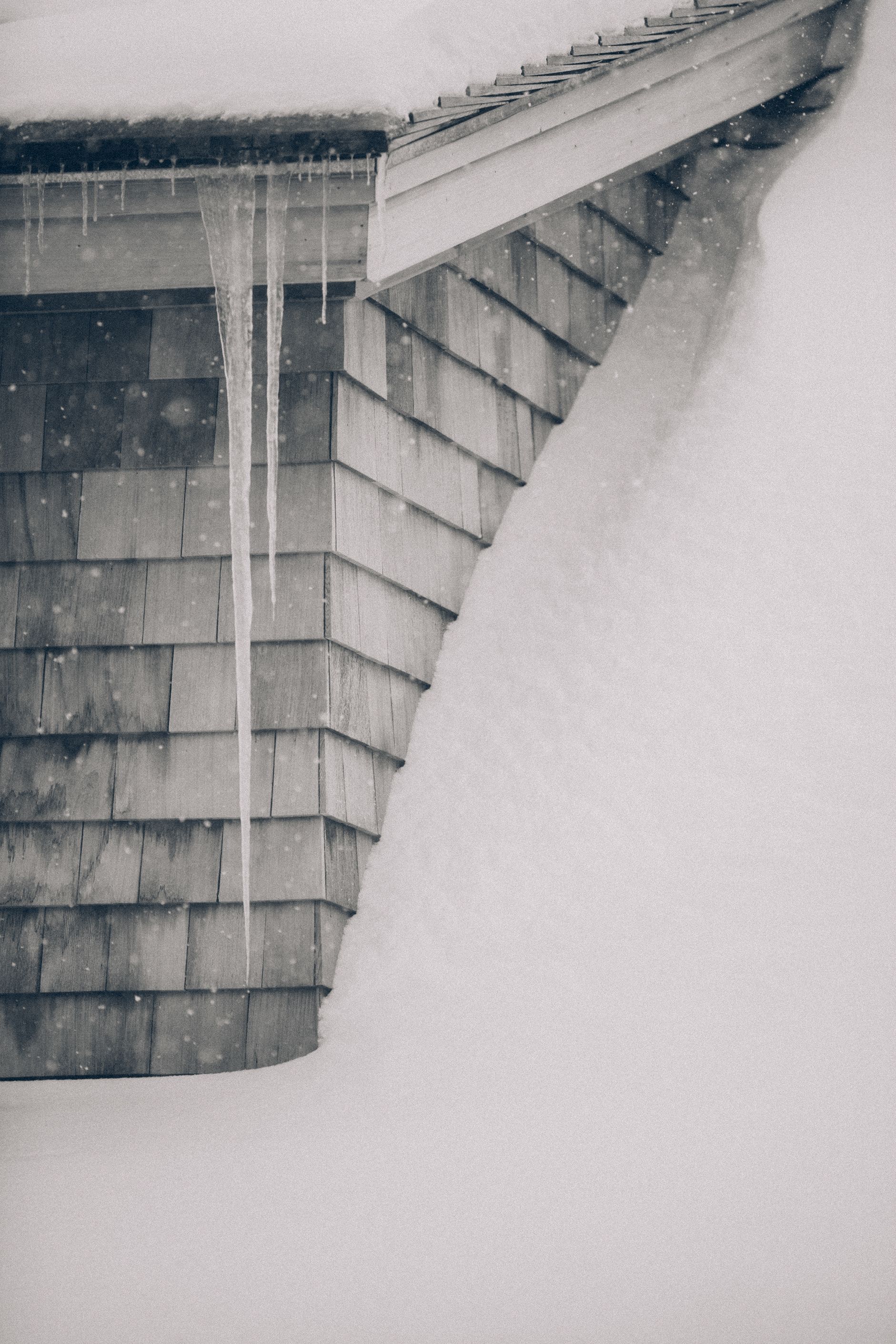 Icicles are hanging from the roof of a house