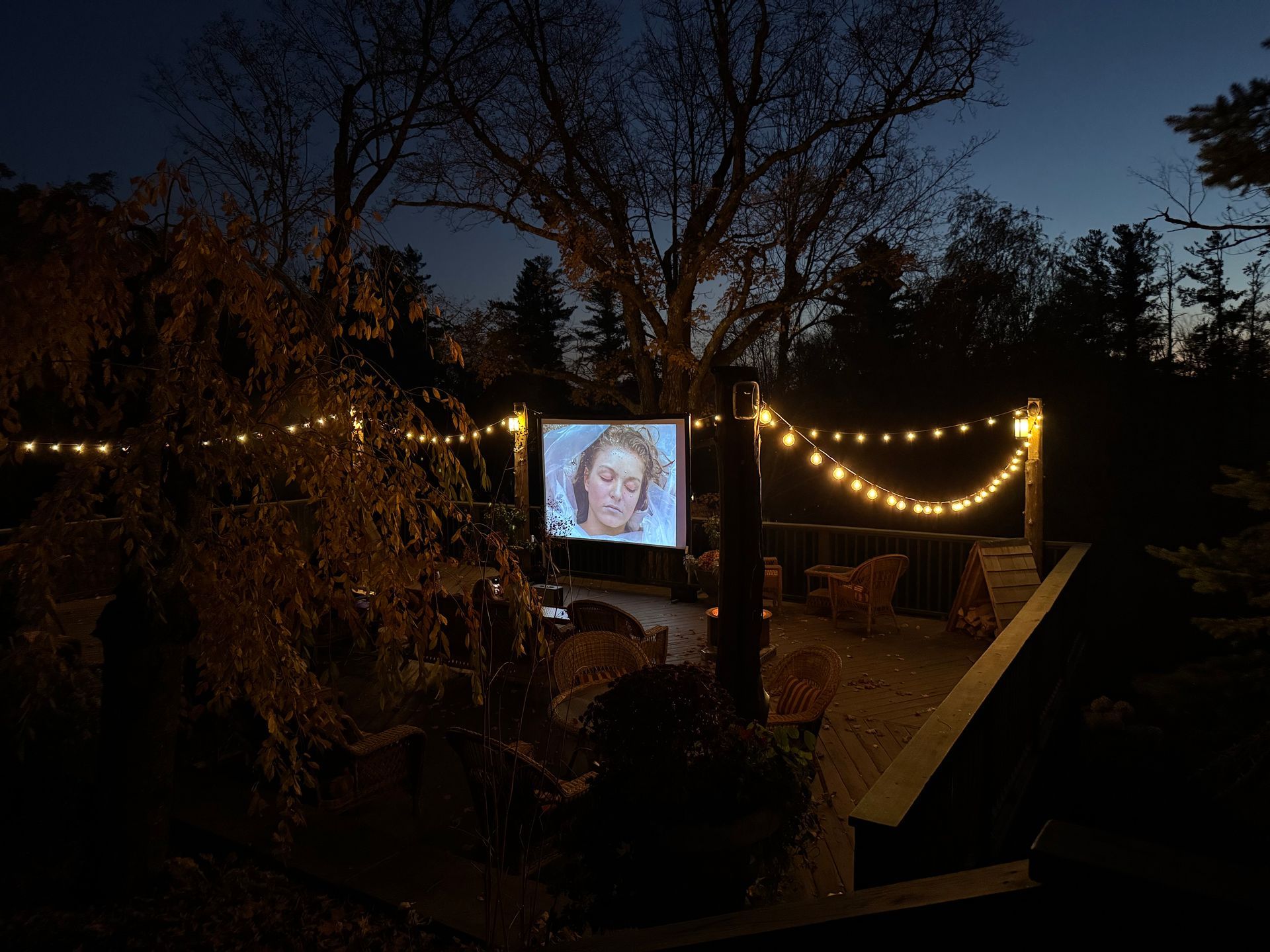 A projector screen with a picture of a woman on it is lit up at night.