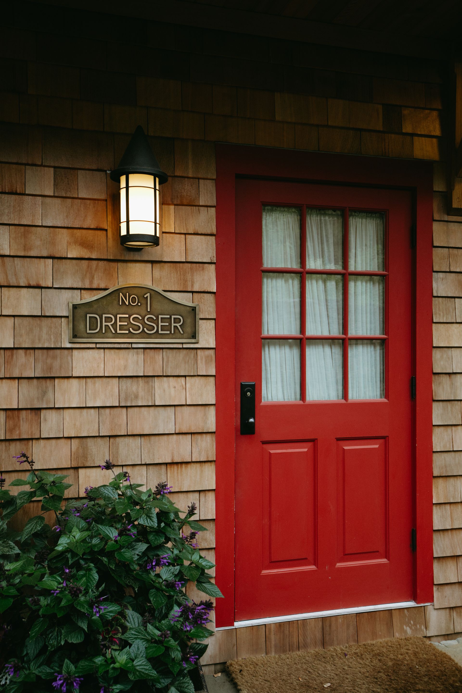 A red door is on the side of a house.