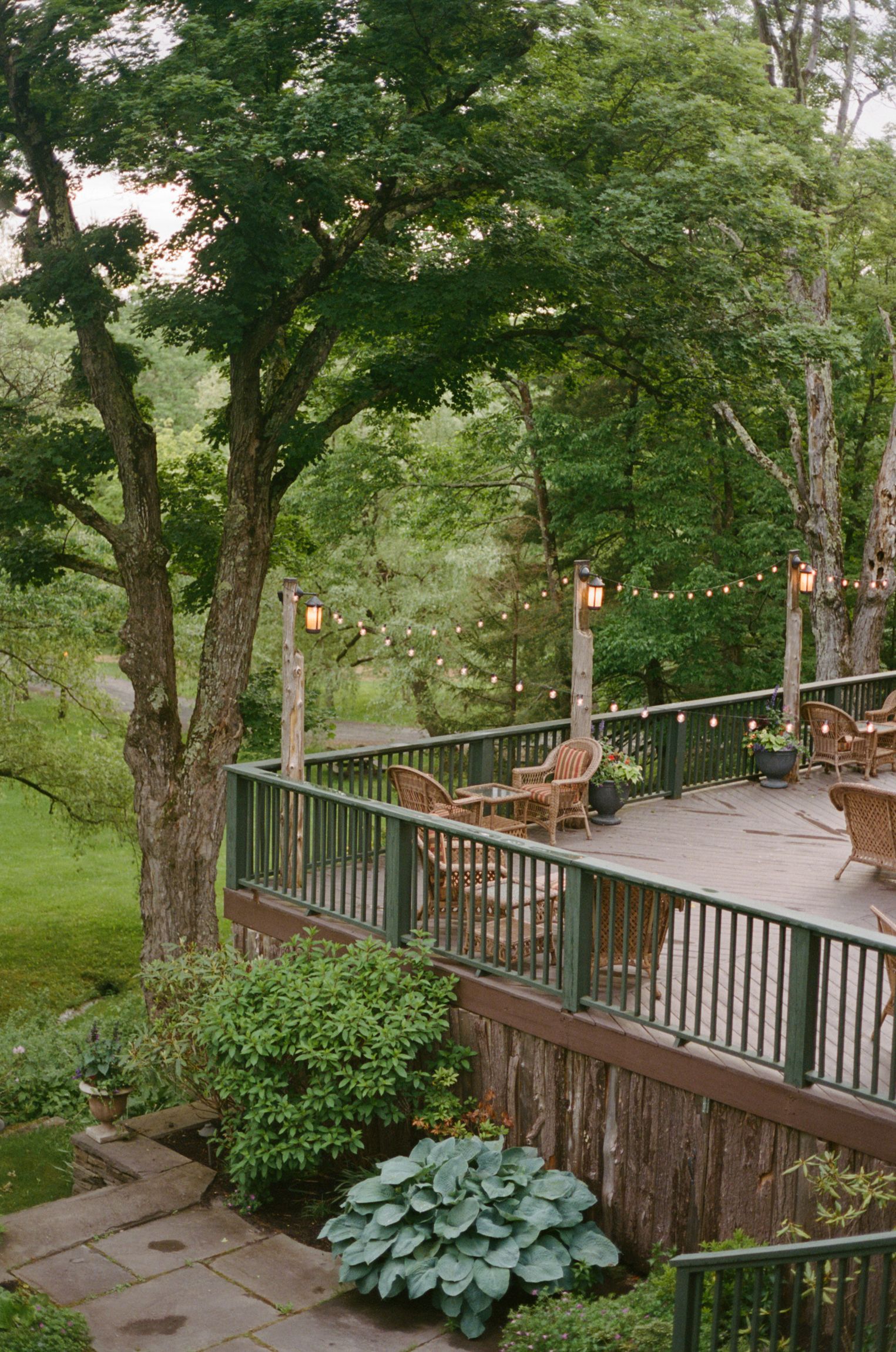 A deck with chairs and tables in the middle of a forest