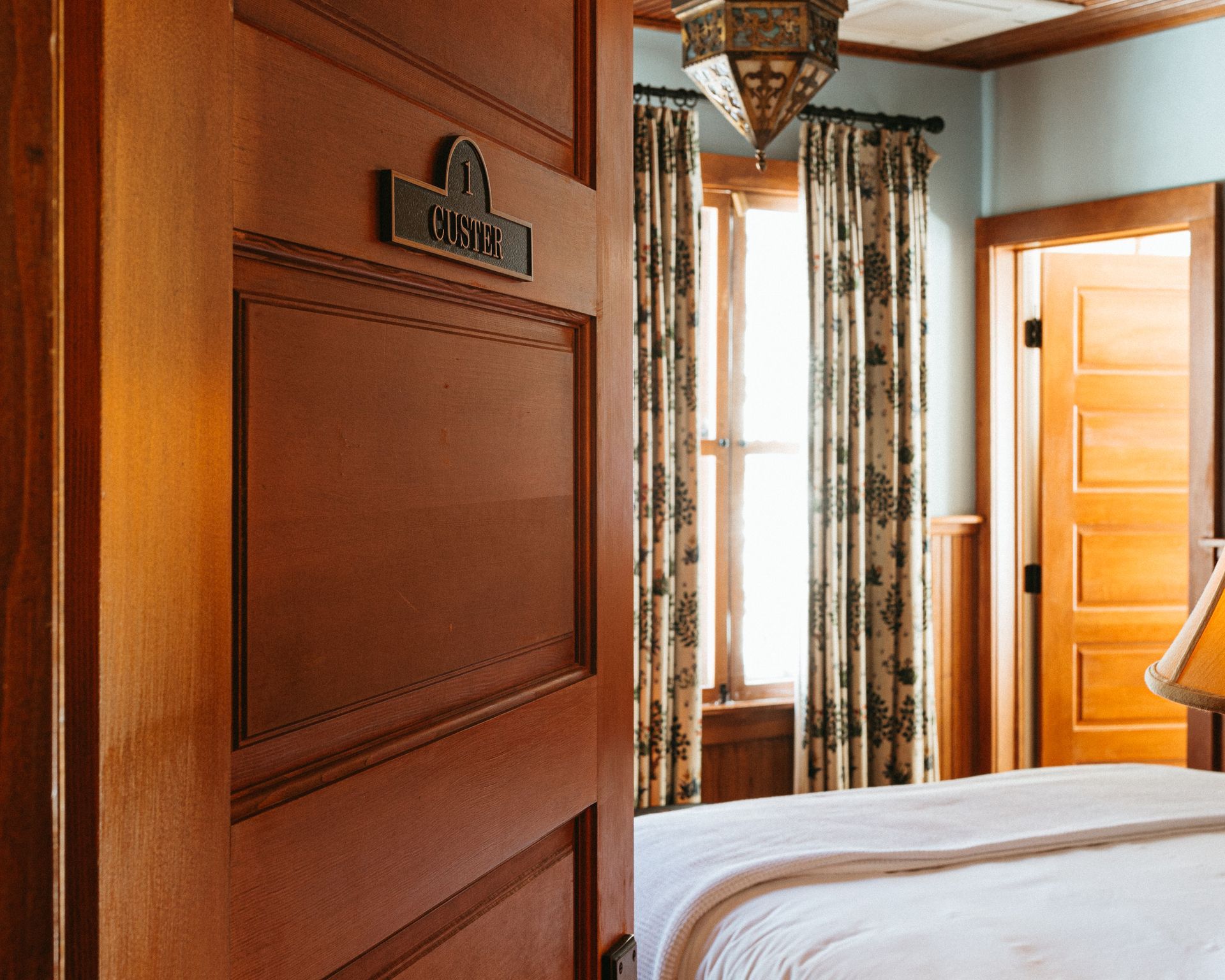 A bedroom with a wooden door and a bed