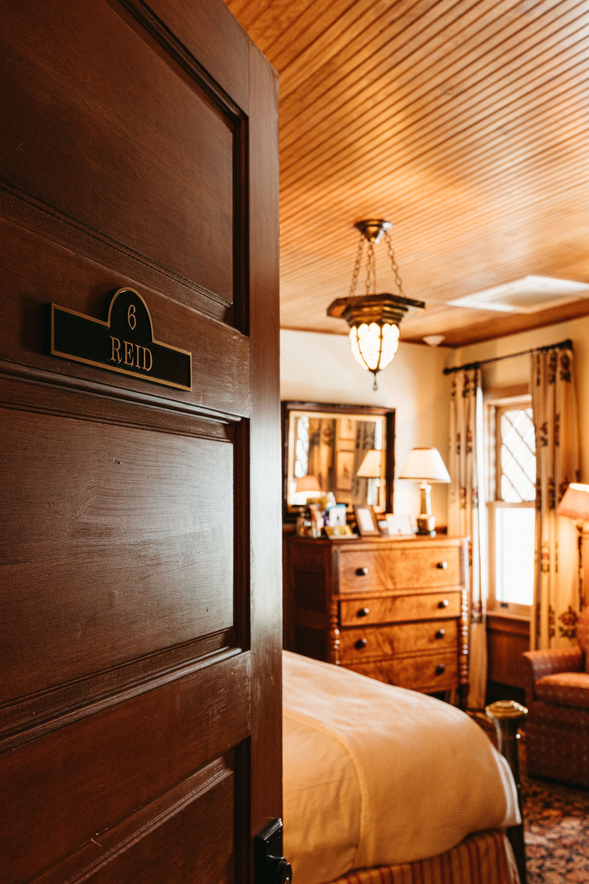 A bedroom with a wooden door and a bed