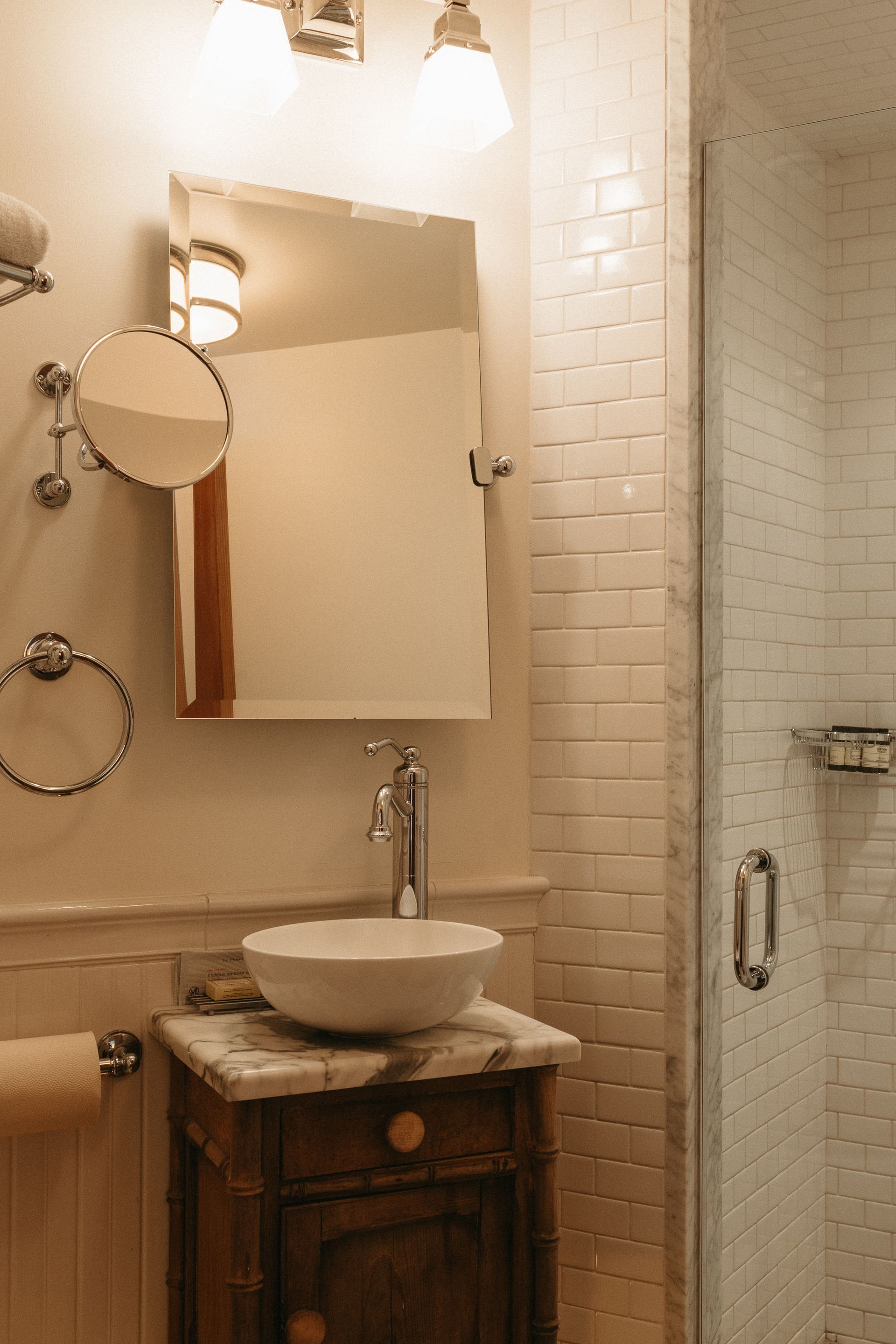 A bathroom with a sink , mirror , and shower.