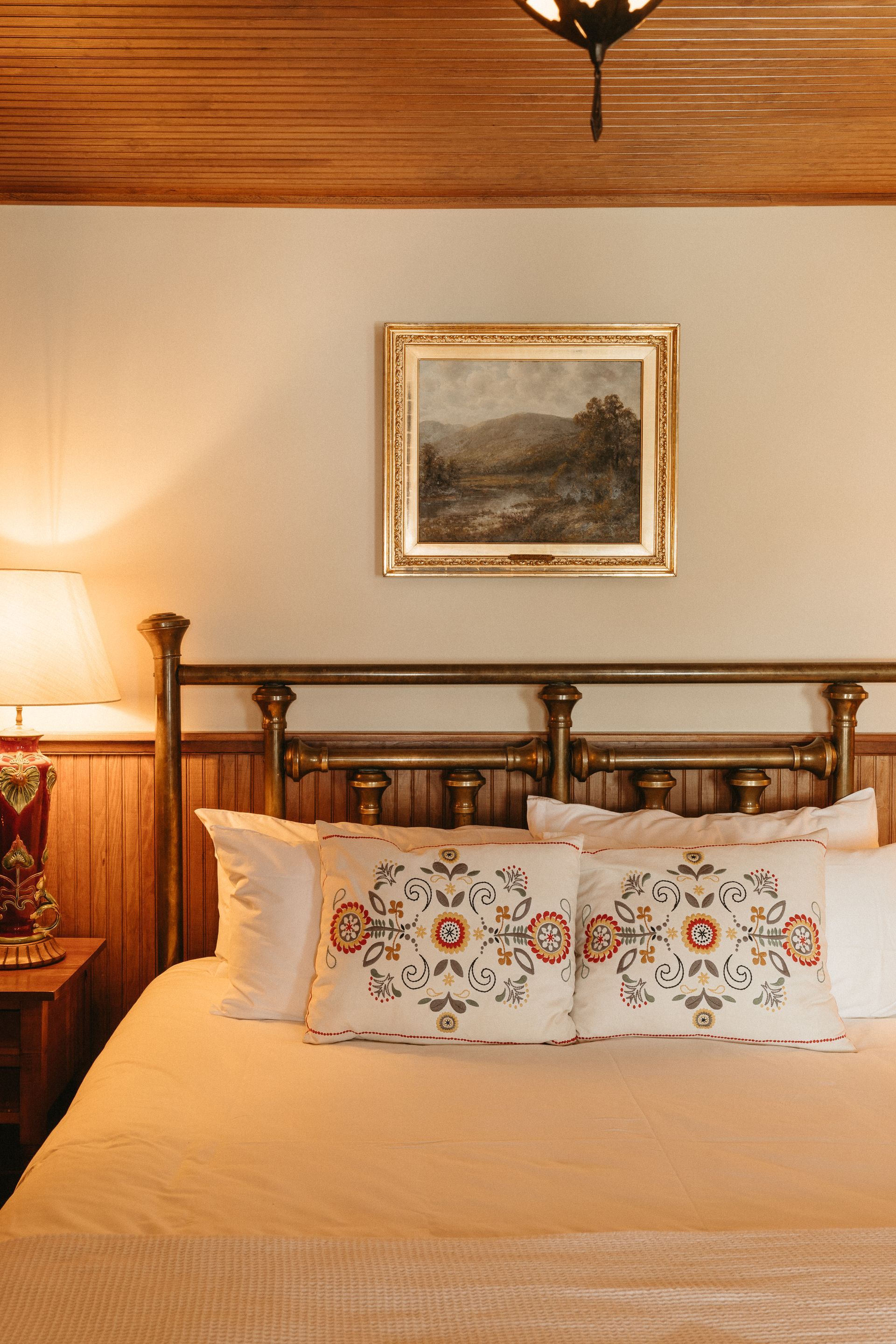 There is a painting on the wall above the bed.