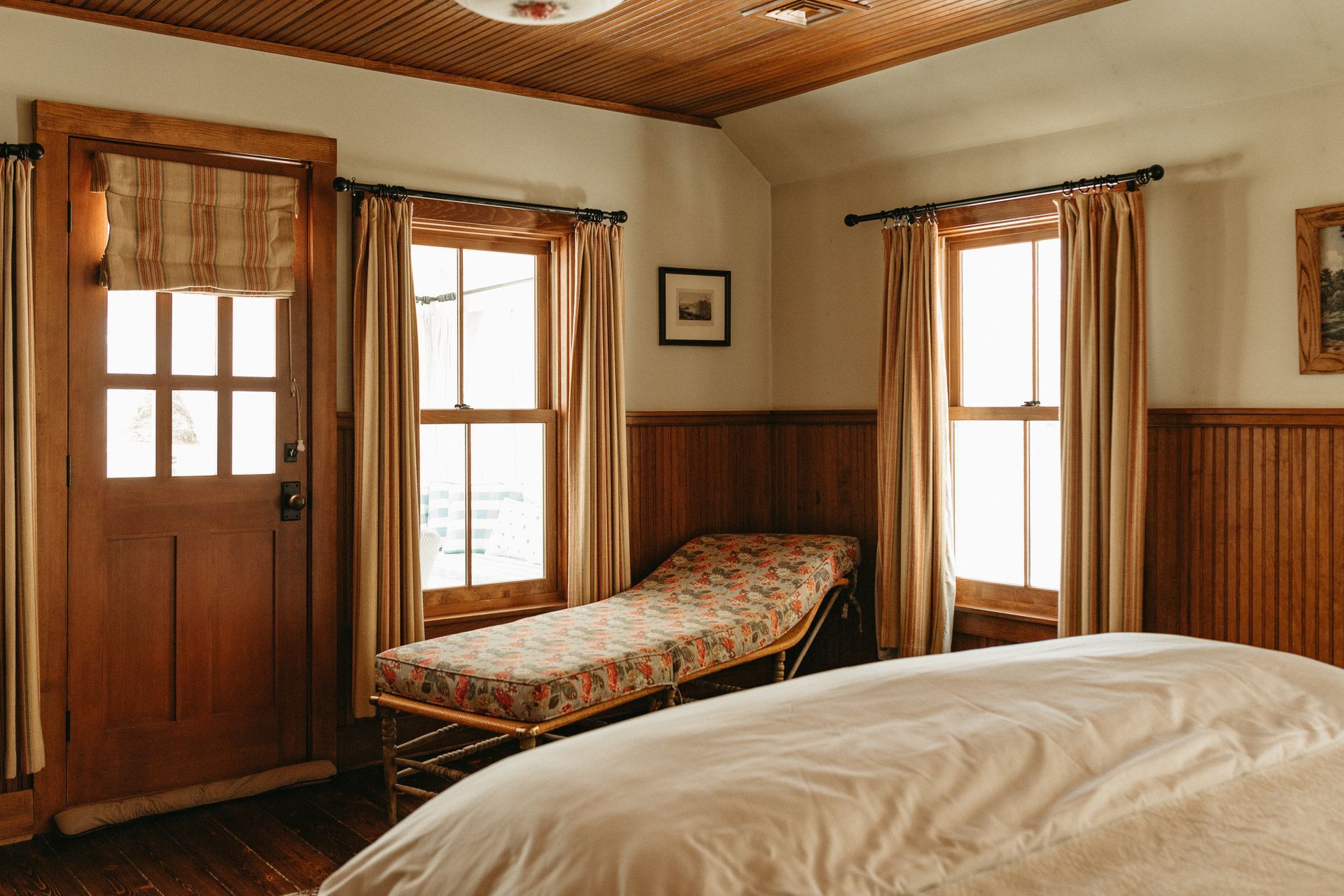 A bedroom with a bed , two beds and a door.