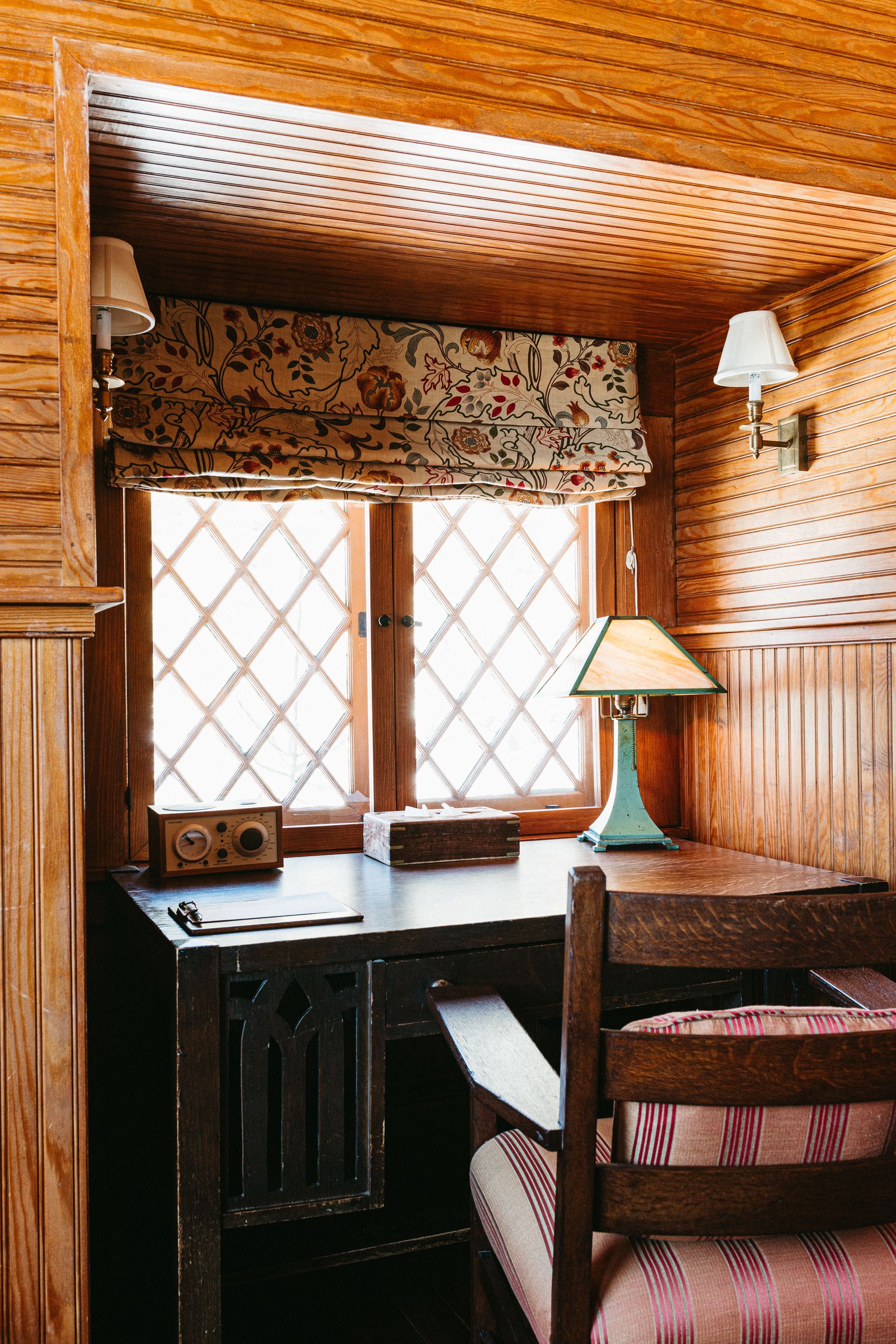 There is a desk and chair in the corner of the room.