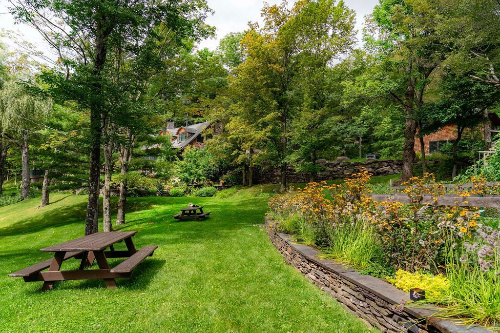 A picnic table is sitting in the middle of a lush green park.