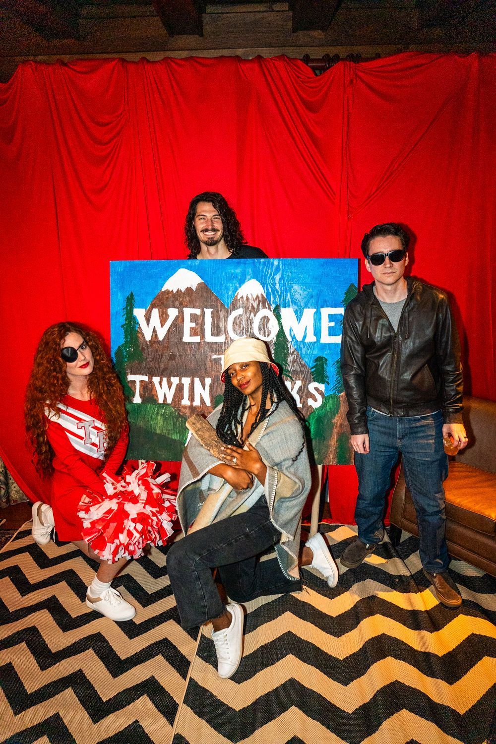 A group of people are posing for a picture in front of a welcome sign.