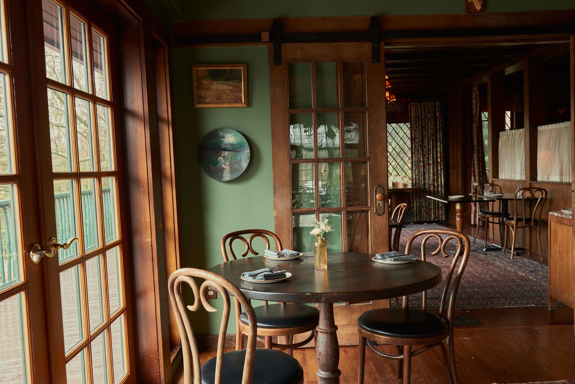 A dining room with a table and chairs and french doors.