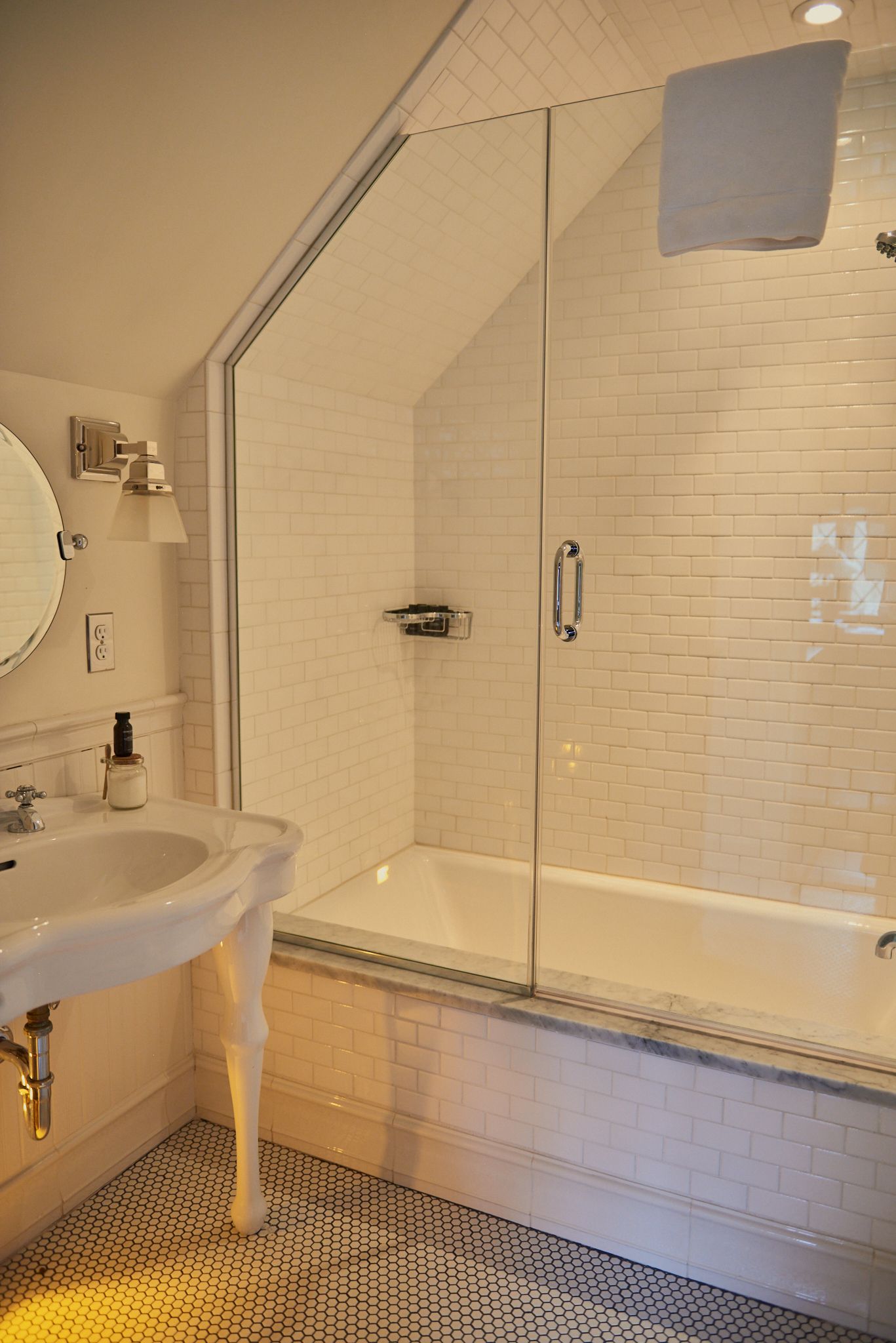 A bathroom with a sink , tub , shower and mirror.