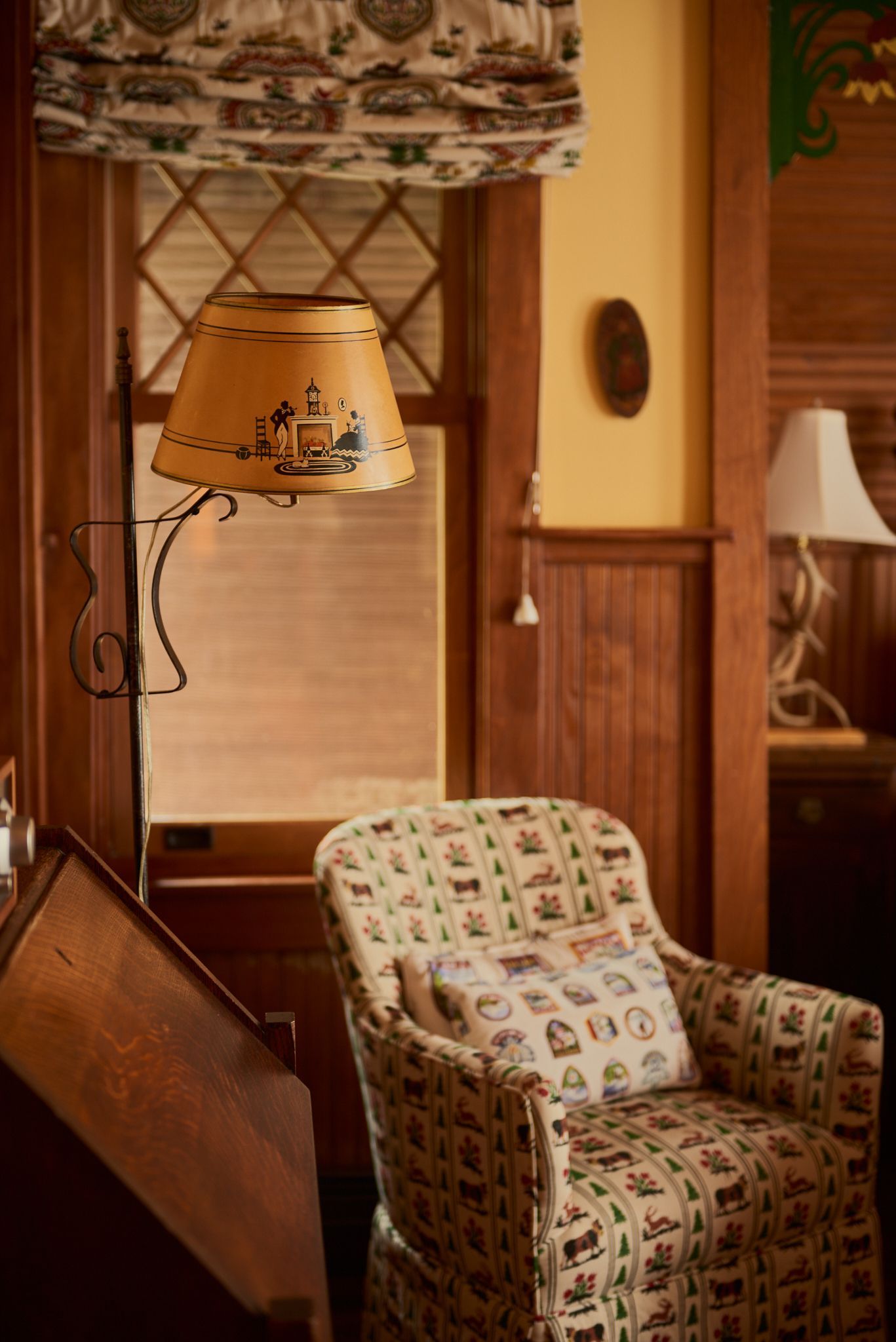 A chair is sitting in a room next to a lamp.