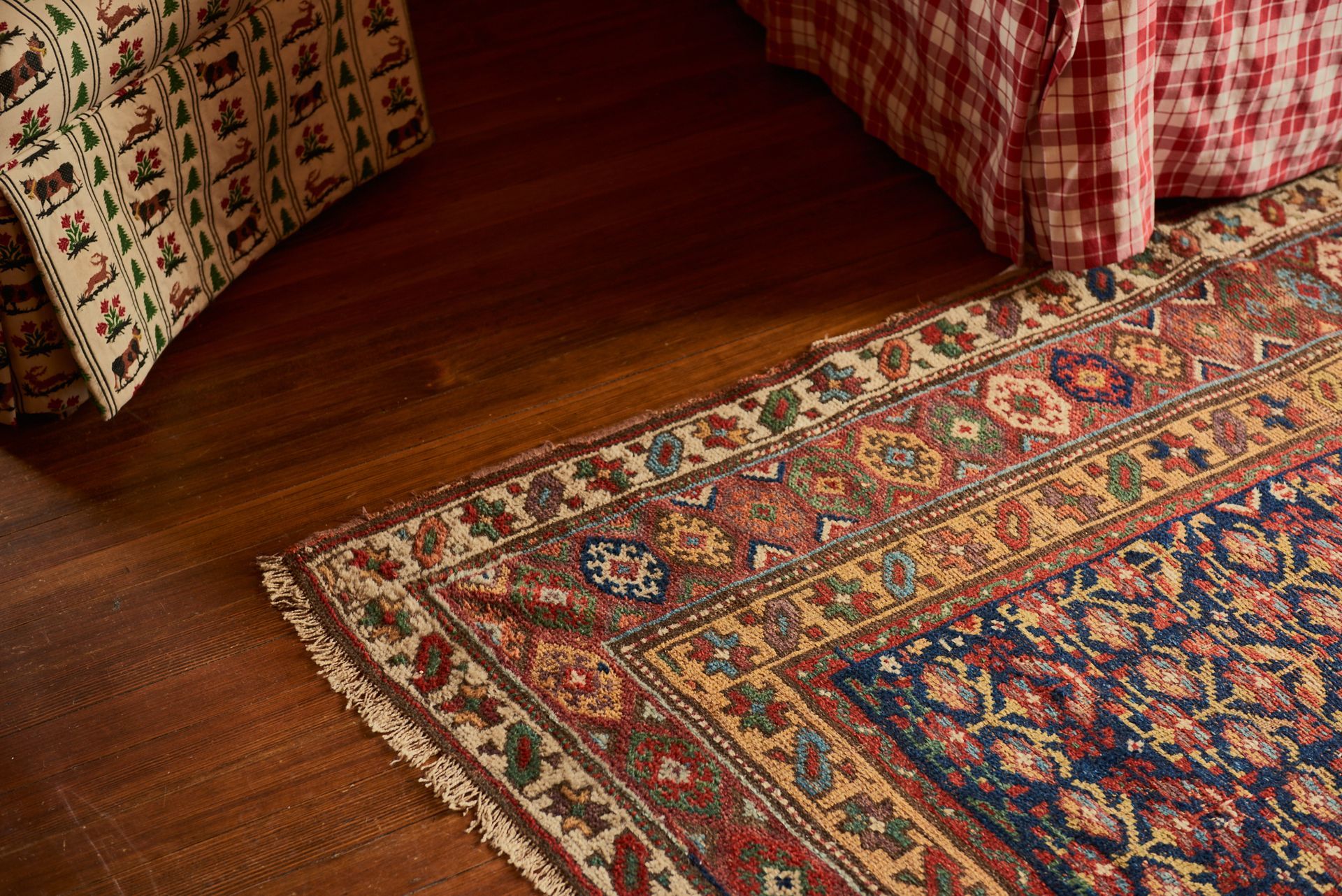 A rug is sitting on a wooden floor next to a bed.
