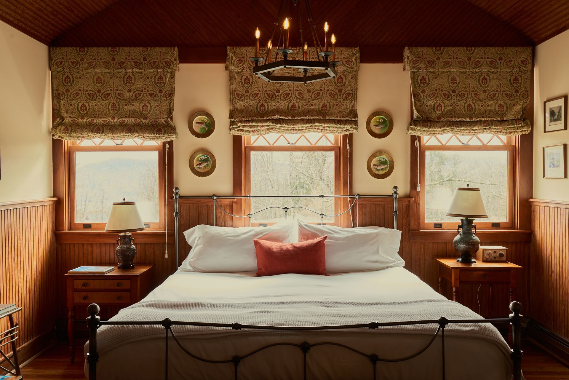 A bedroom with a bed and a chandelier hanging from the ceiling