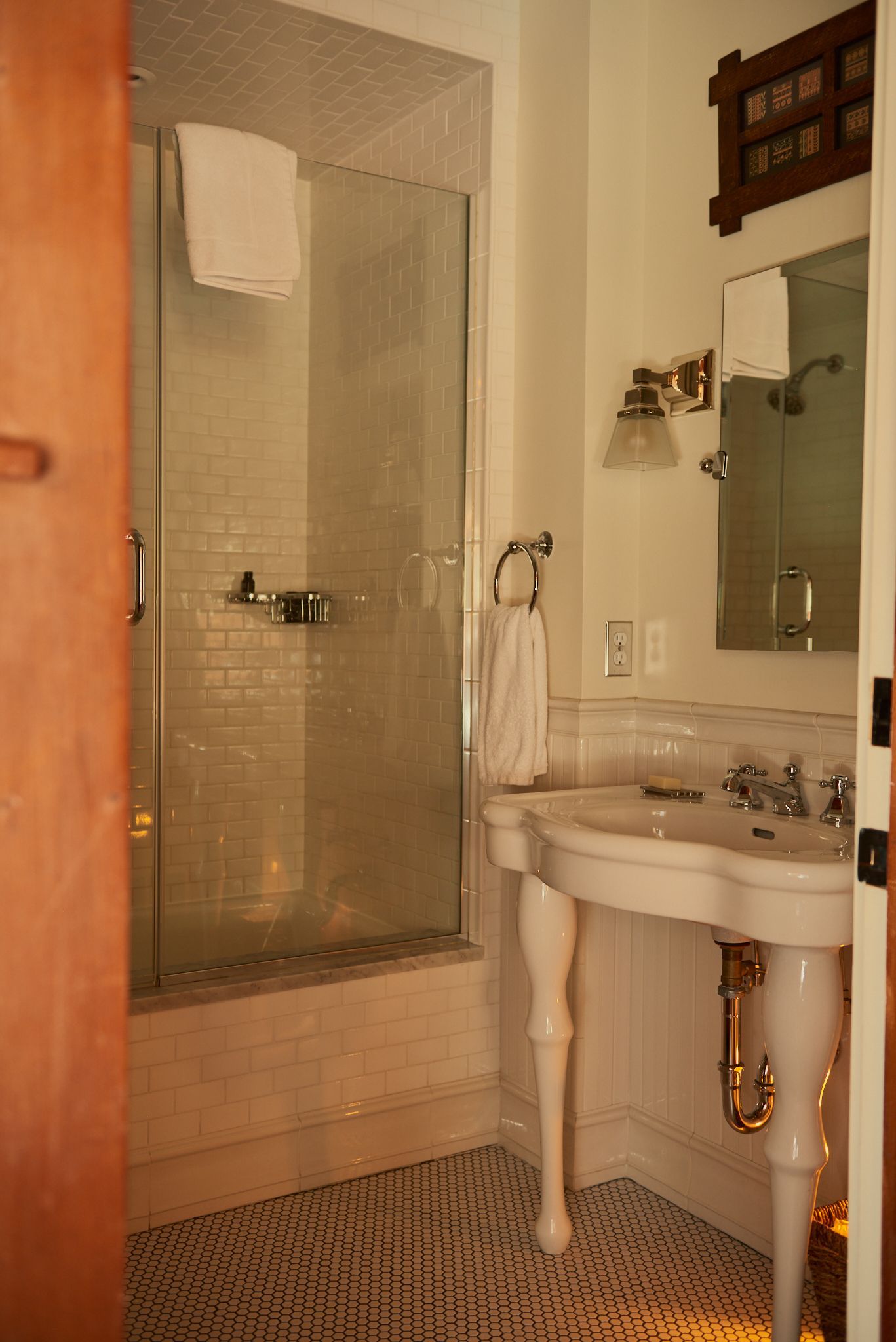 A bathroom with a sink , mirror and shower.
