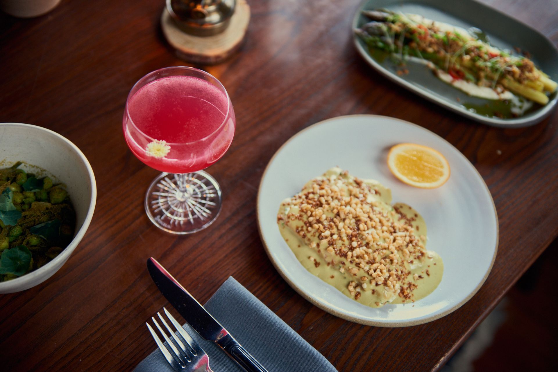 A table topped with plates of food and a drink.