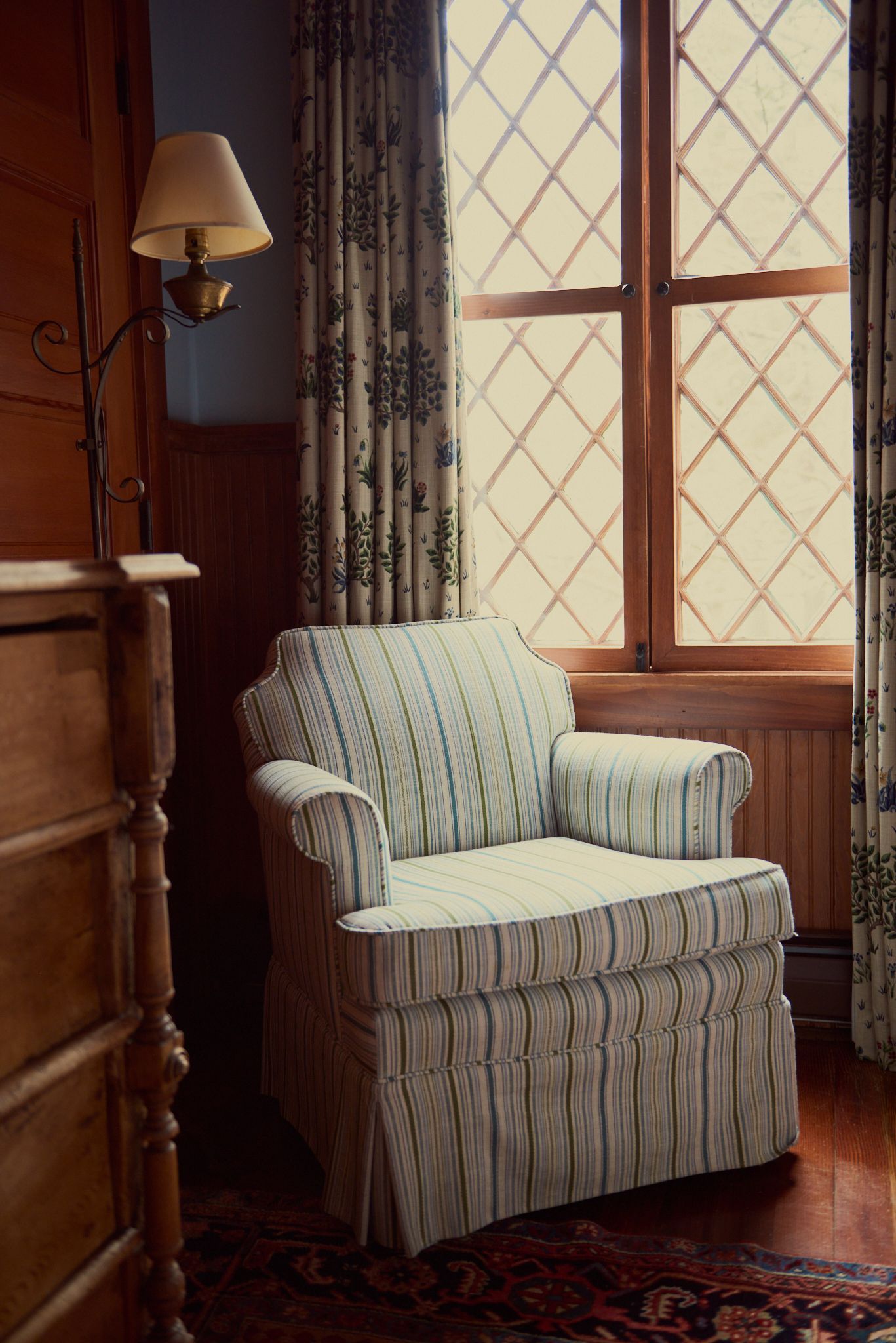 A chair sits in front of a window in a room