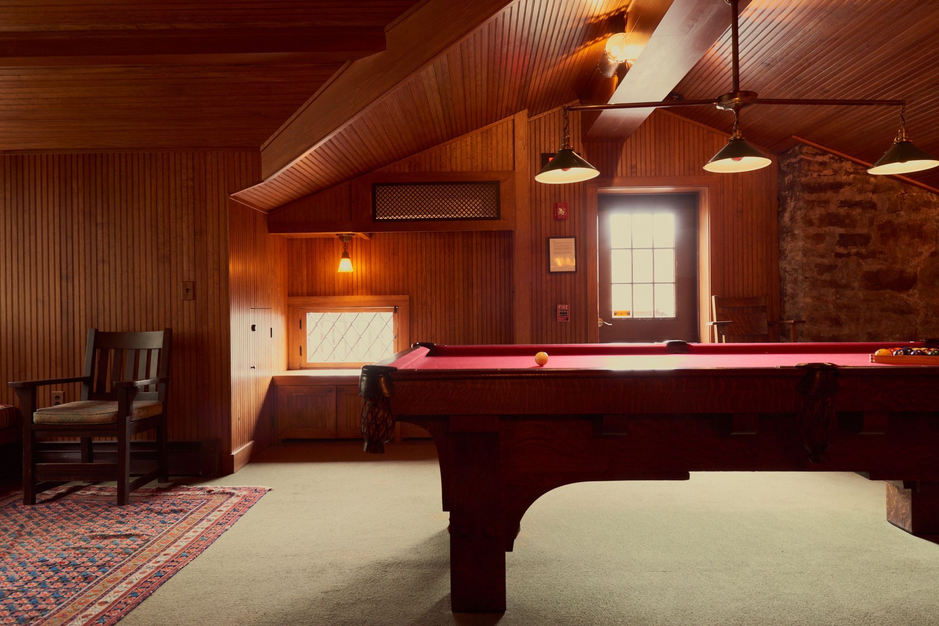 A pool table in a room with wood paneling