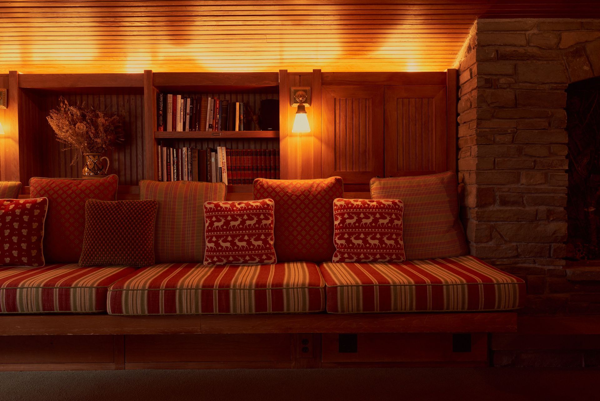 A living room with a couch and pillows and a fireplace.