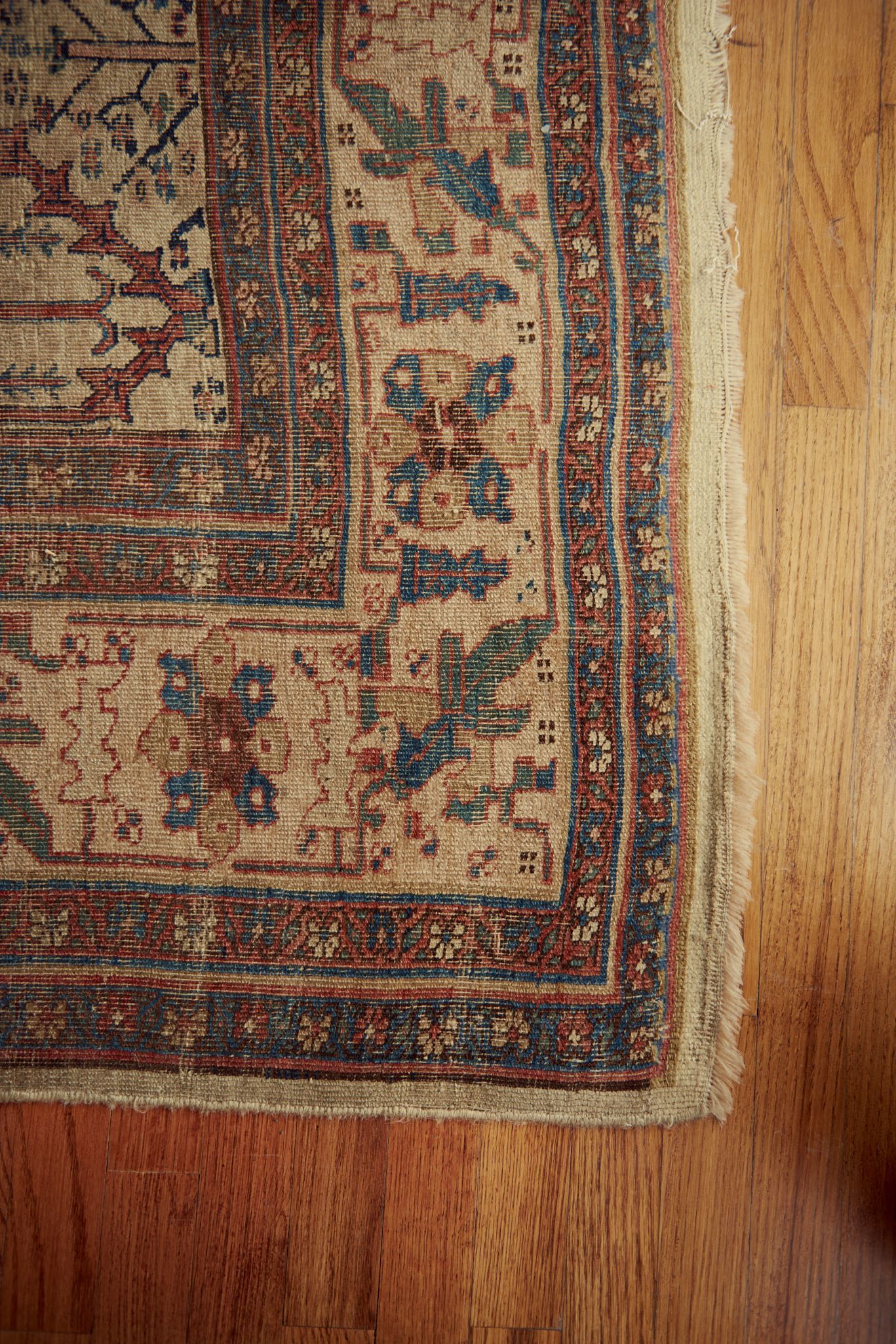 A close up of a rug on a wooden floor.