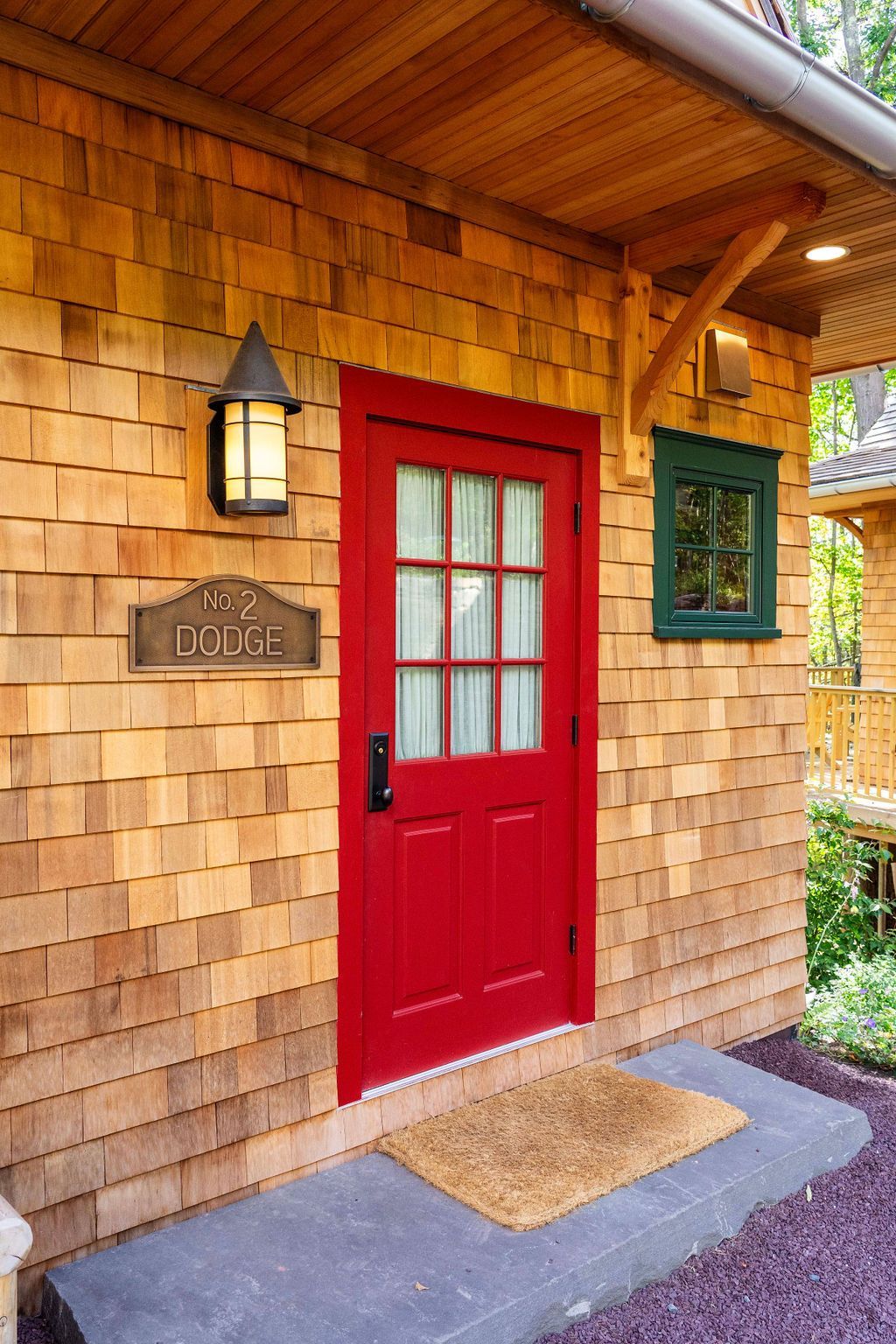 A red door is on the side of a house