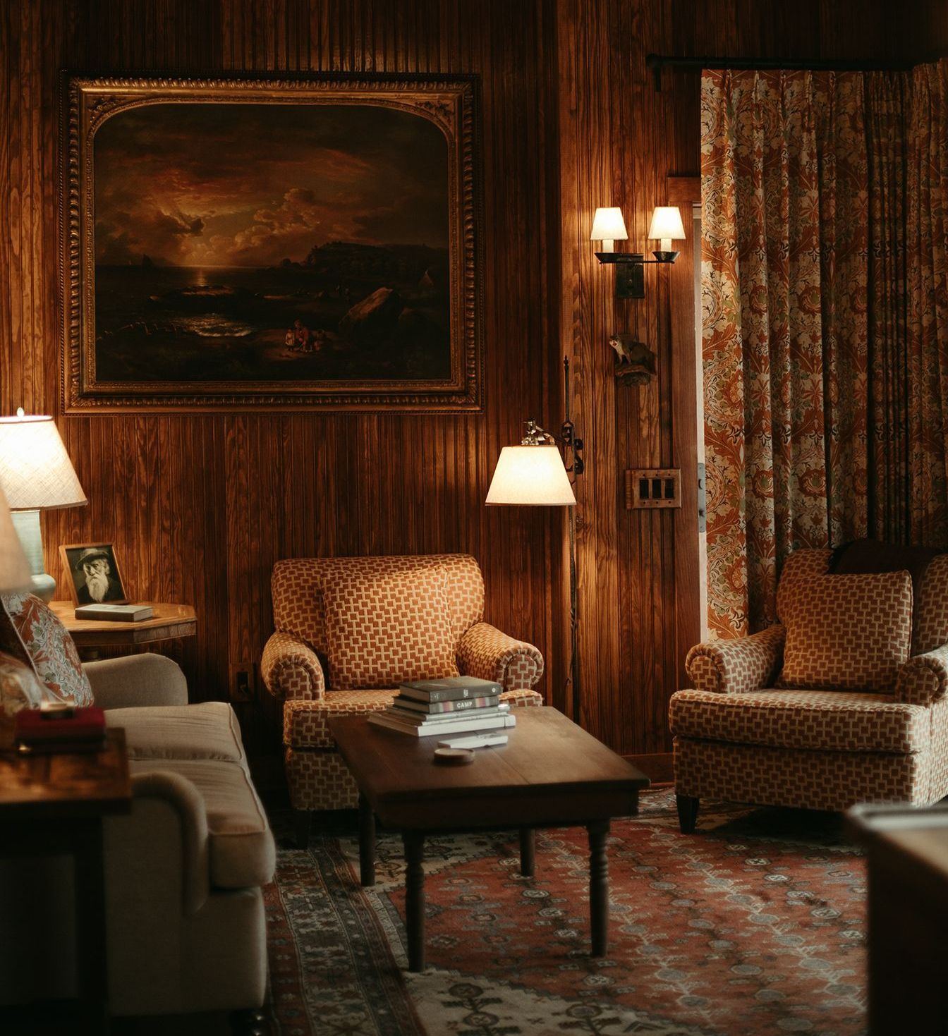 A living room with furniture and a painting on the wall