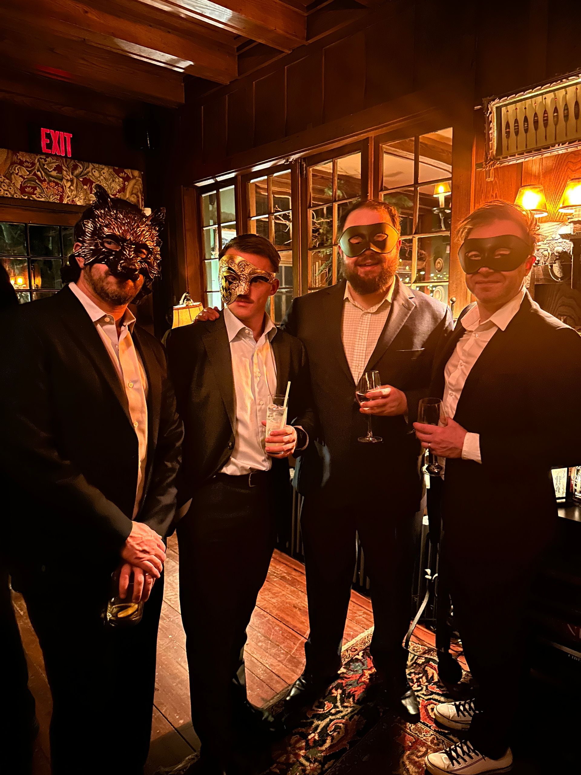 A group of men wearing masks are standing next to each other in a room.