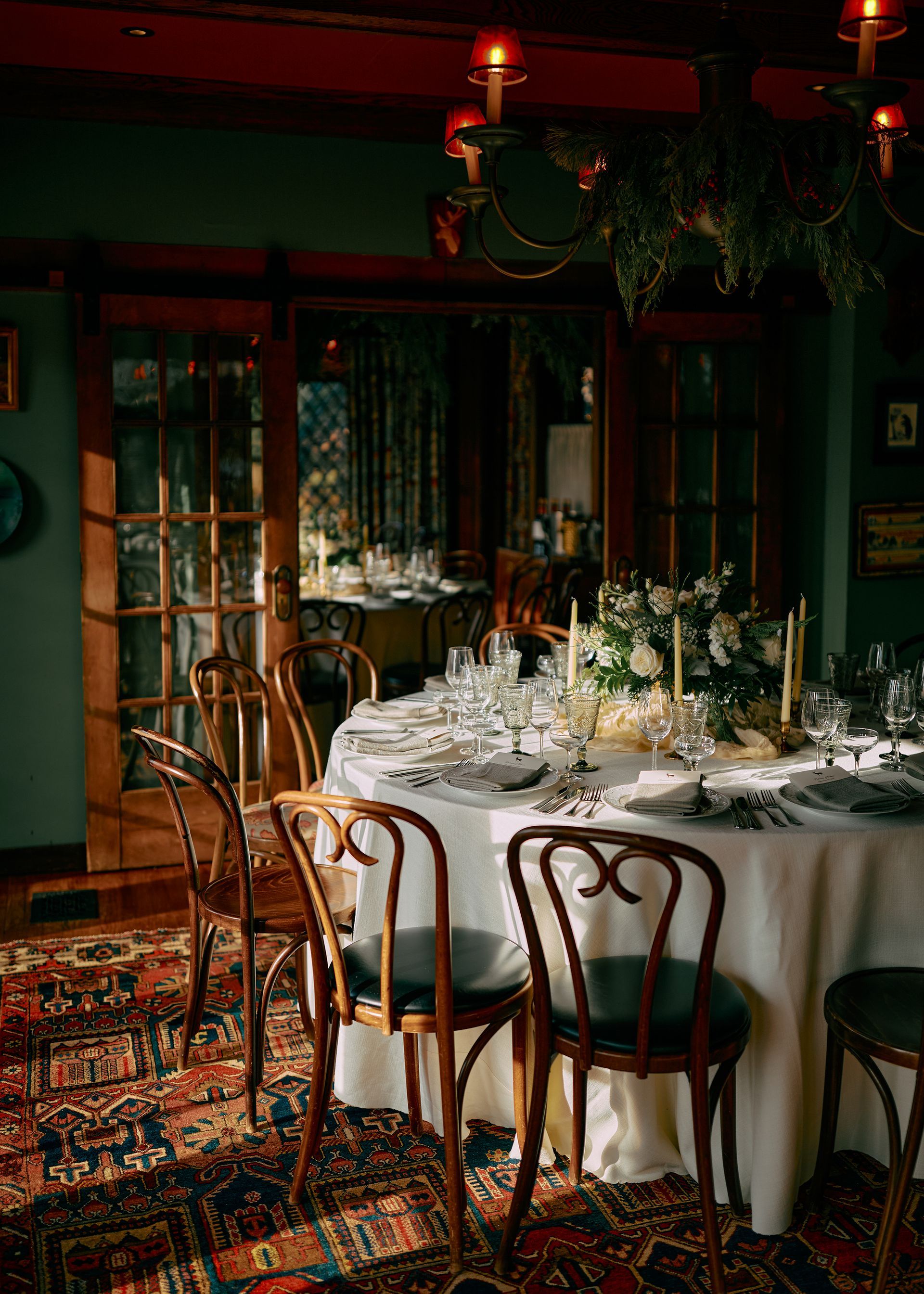 A dining room with a table and chairs set for a wedding reception.