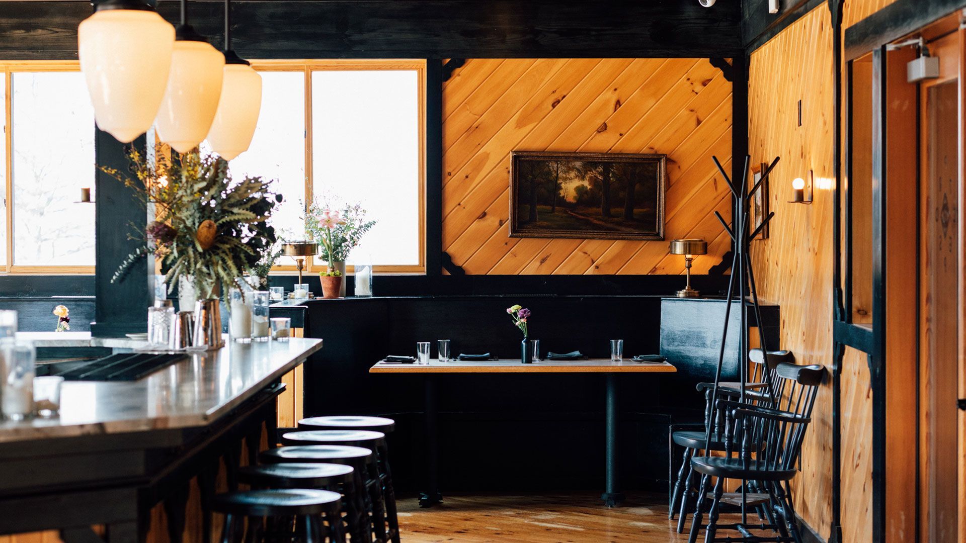 A restaurant with a wooden wall and a painting of a deer on the wall.