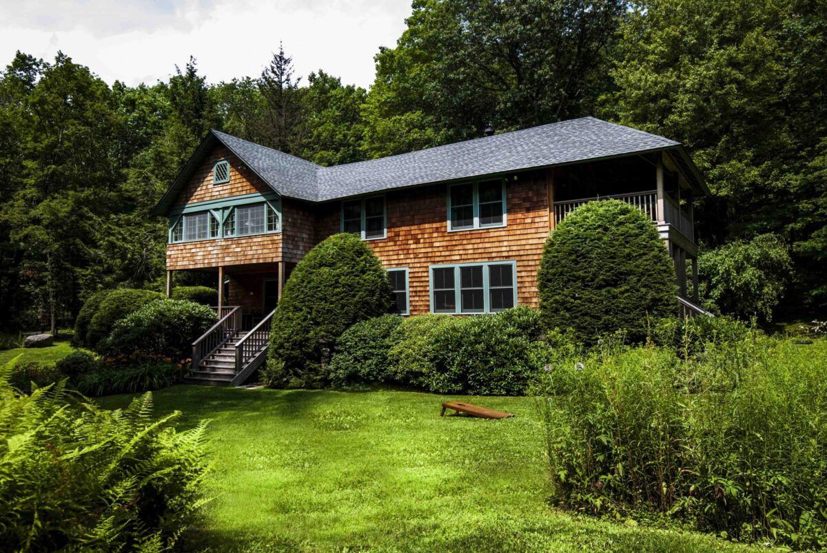 A large house in the middle of a lush green forest