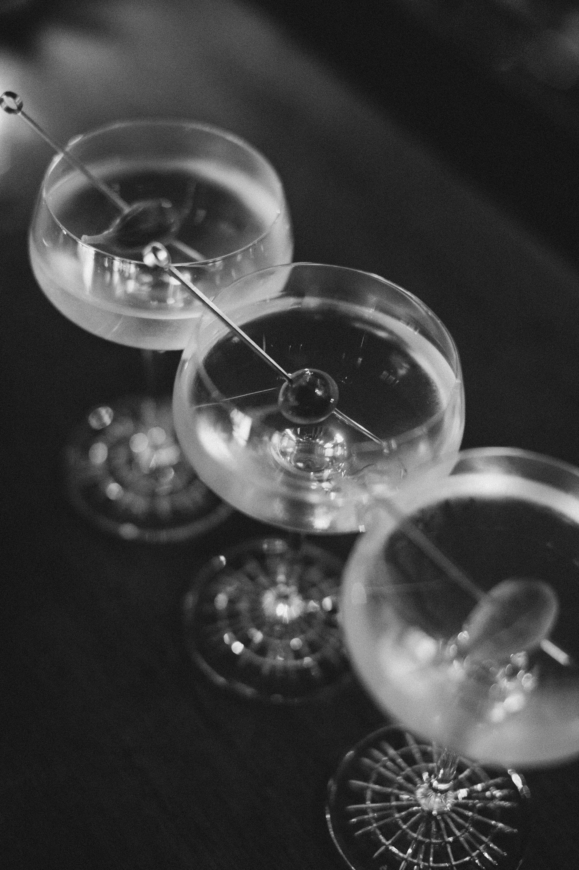 Three martini glasses are lined up in a row on a table.