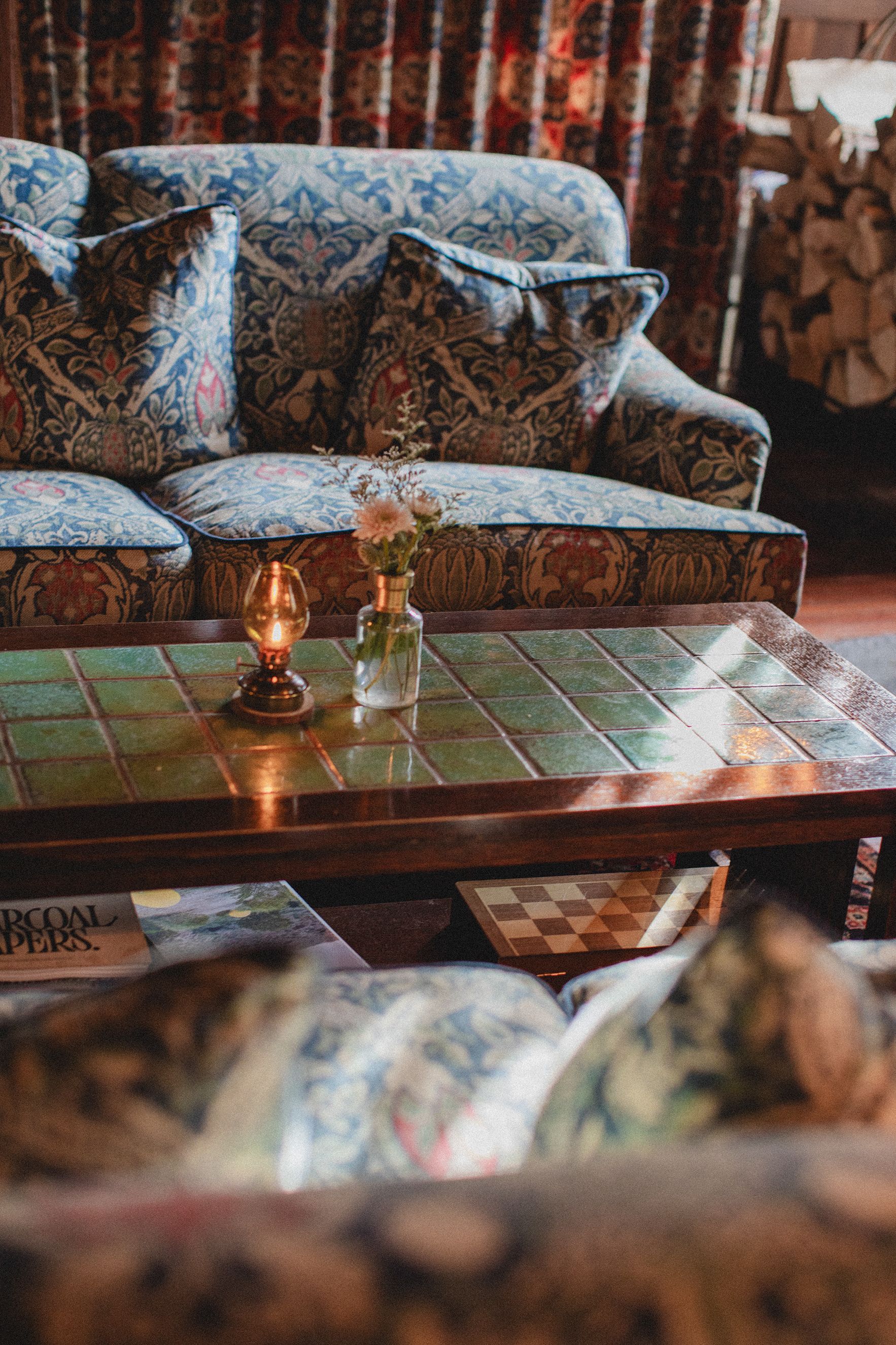 A living room with a couch and a coffee table with a candle on it.