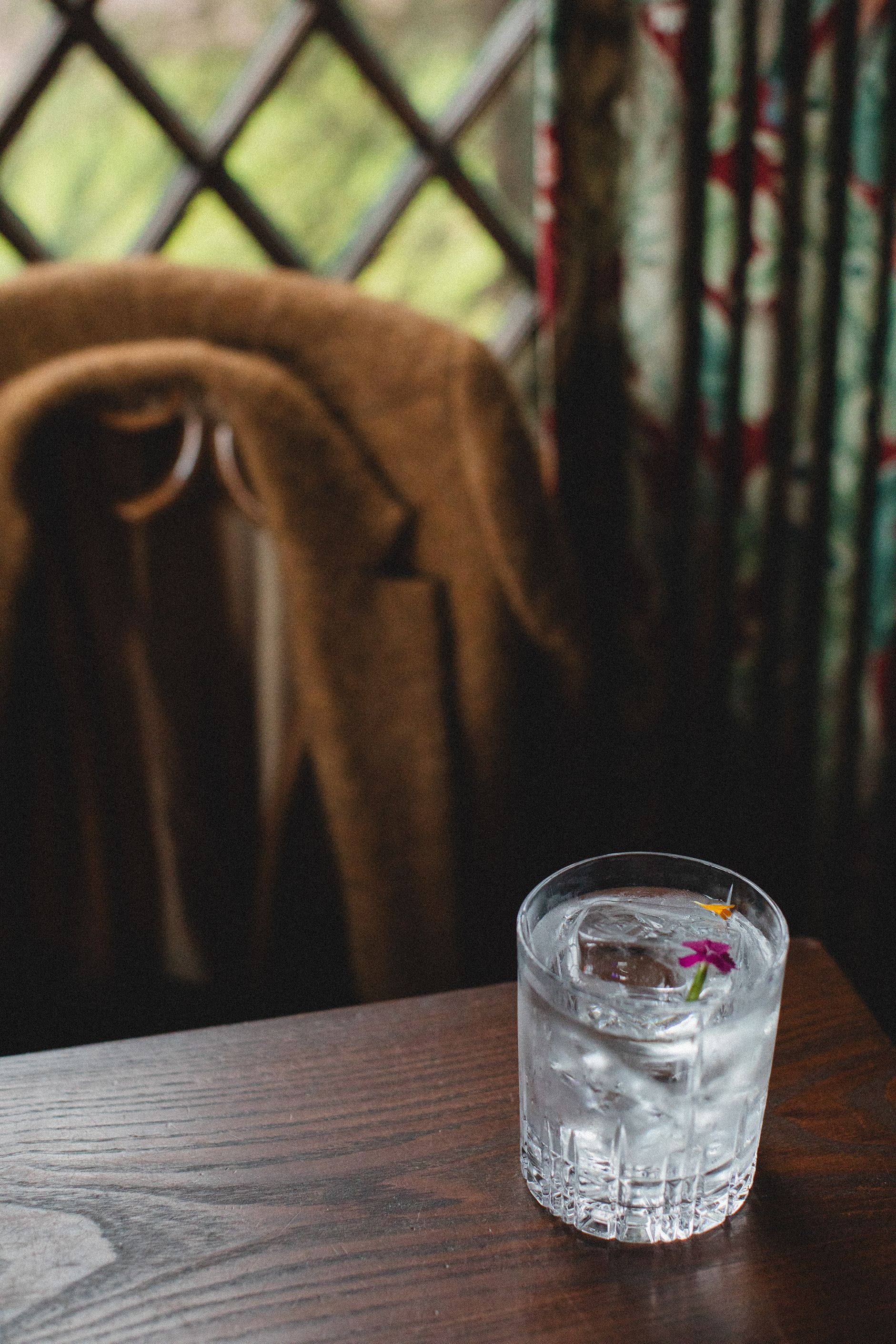 A glass of water is sitting on a wooden table.