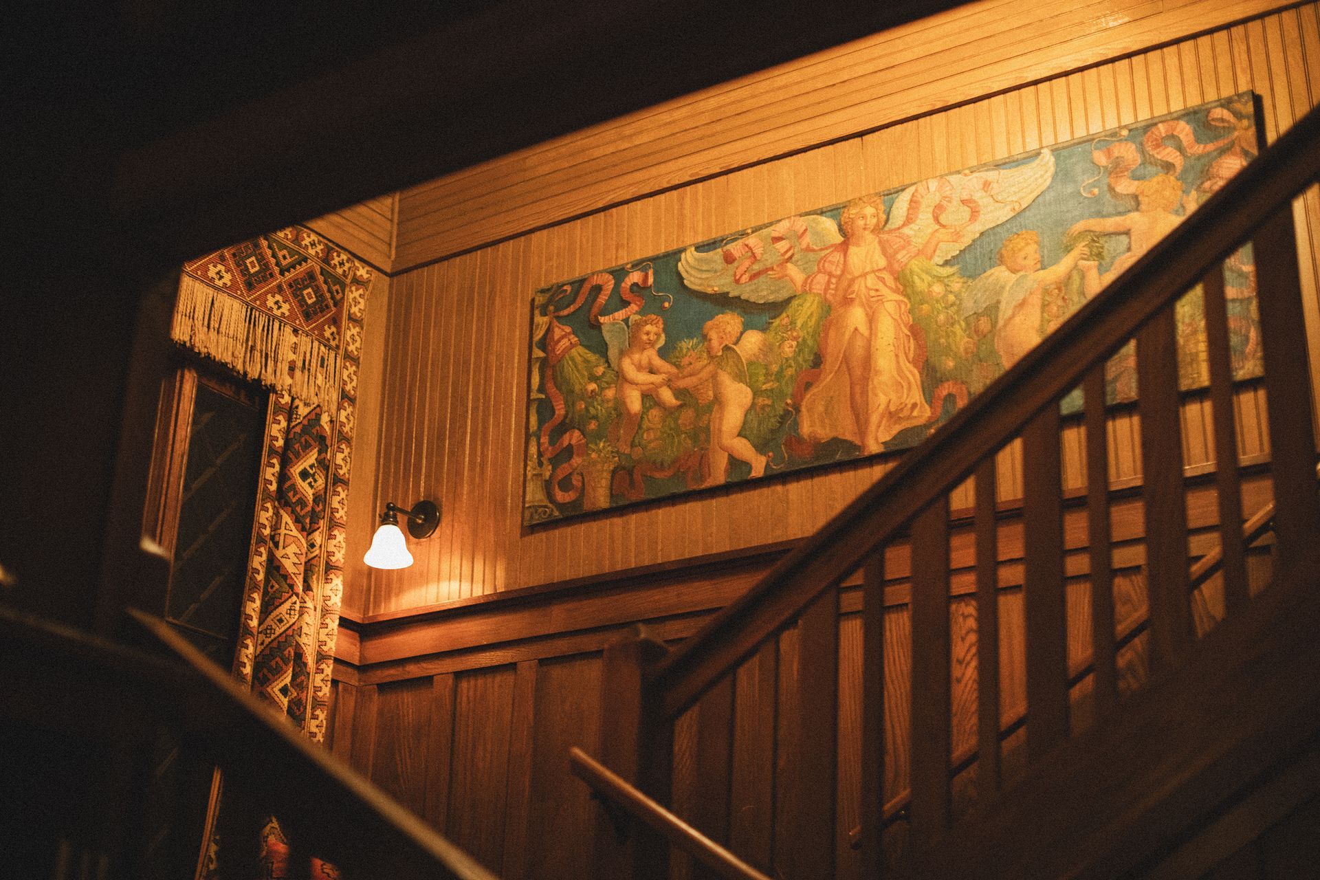 A wooden staircase with a painting on the wall above it
