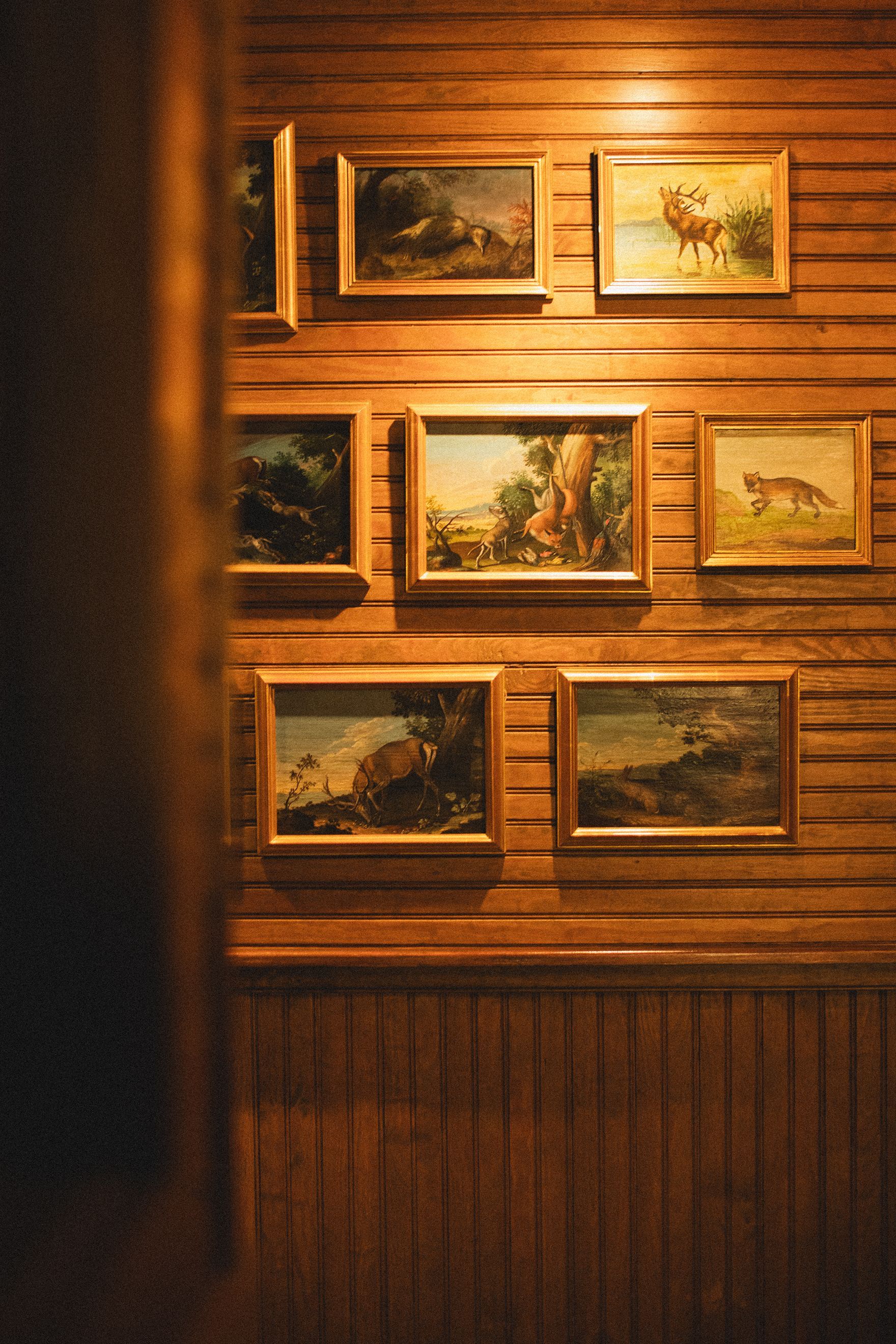A wooden wall with a bunch of paintings on it