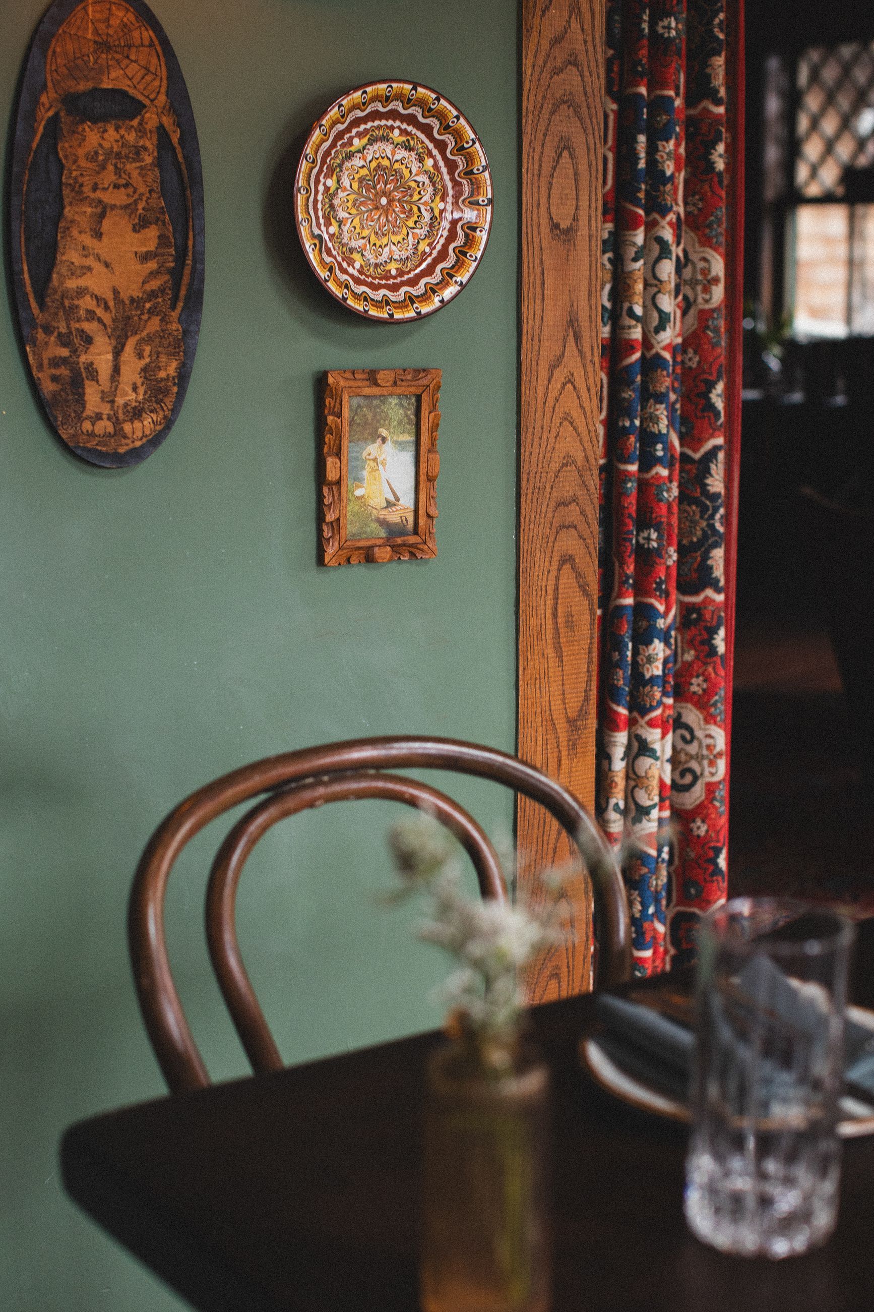 A table with a vase of flowers on it and plates on the wall