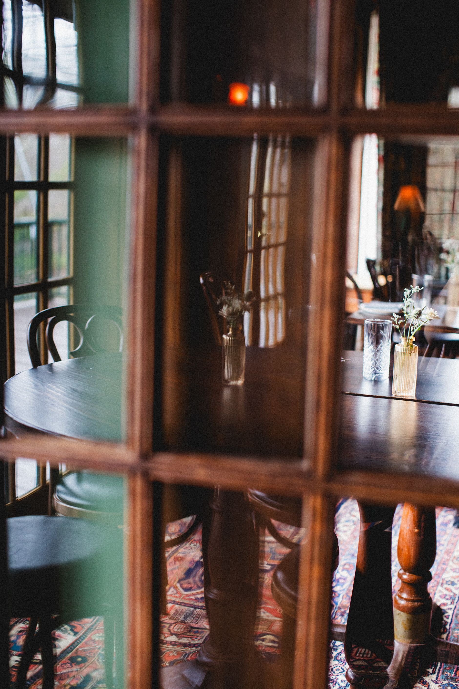A table and chairs are reflected in a window in a room.