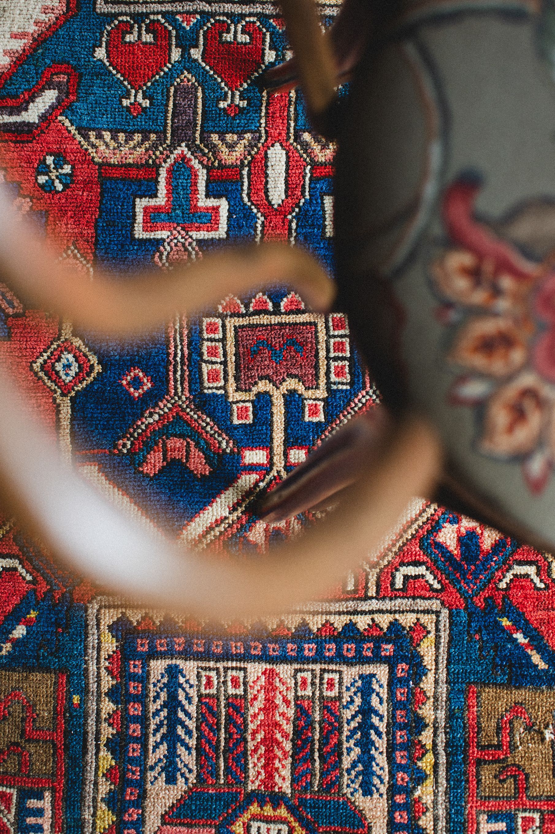 A person is standing on top of a colorful rug.
