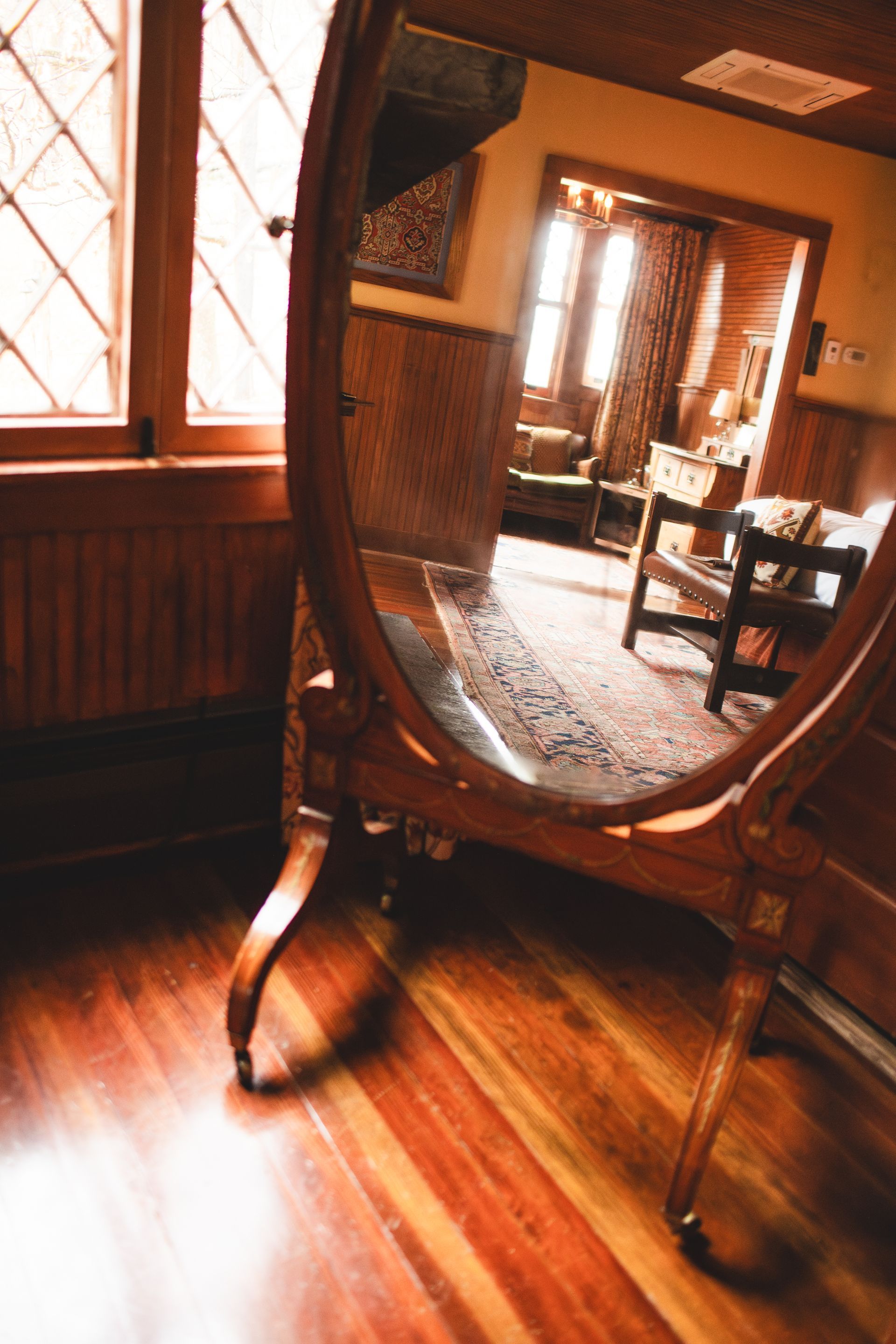 A mirror is sitting on a wooden floor in a room