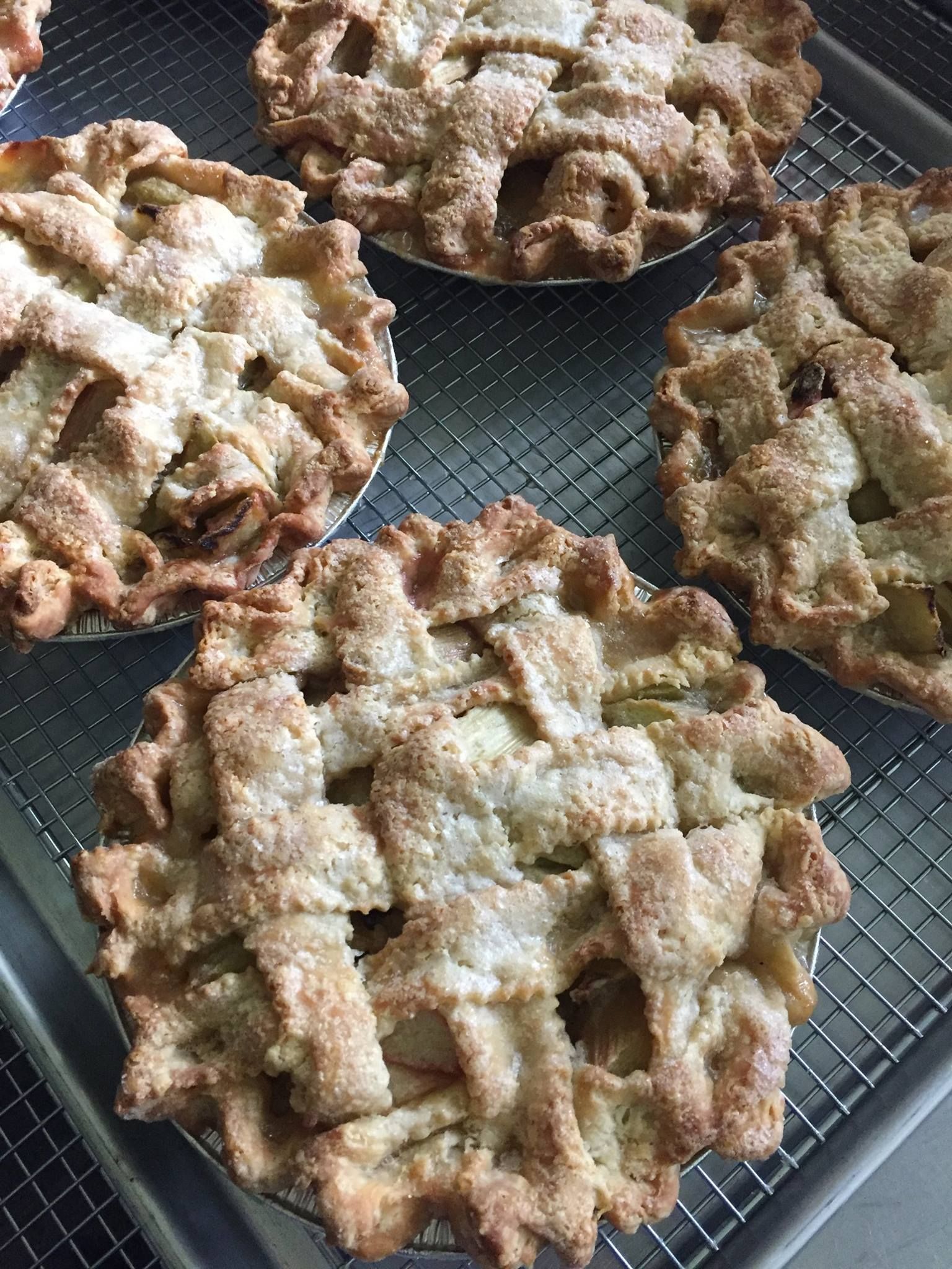 A tray of apple pies sitting on top of a wire rack.