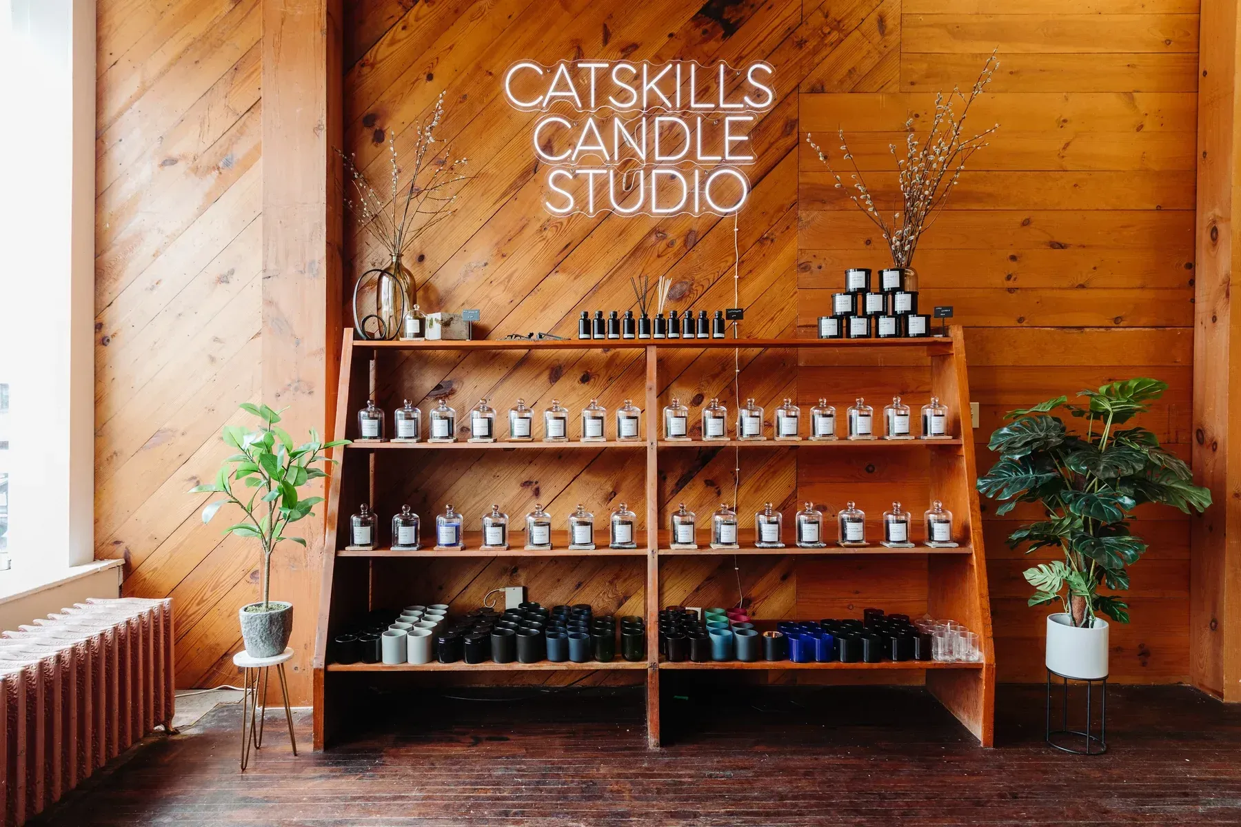 A store with a wooden wall and shelves filled with candles.