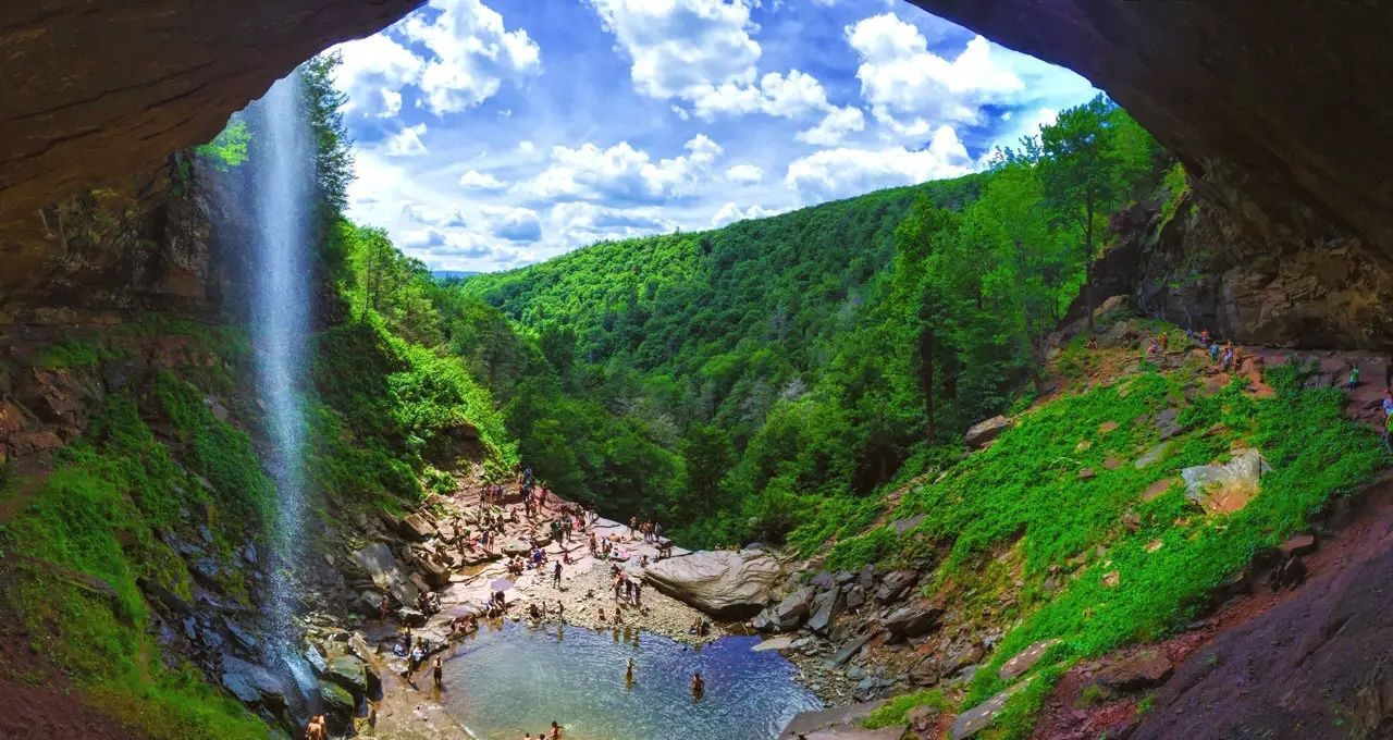 A waterfall is visible from the inside of a cave.