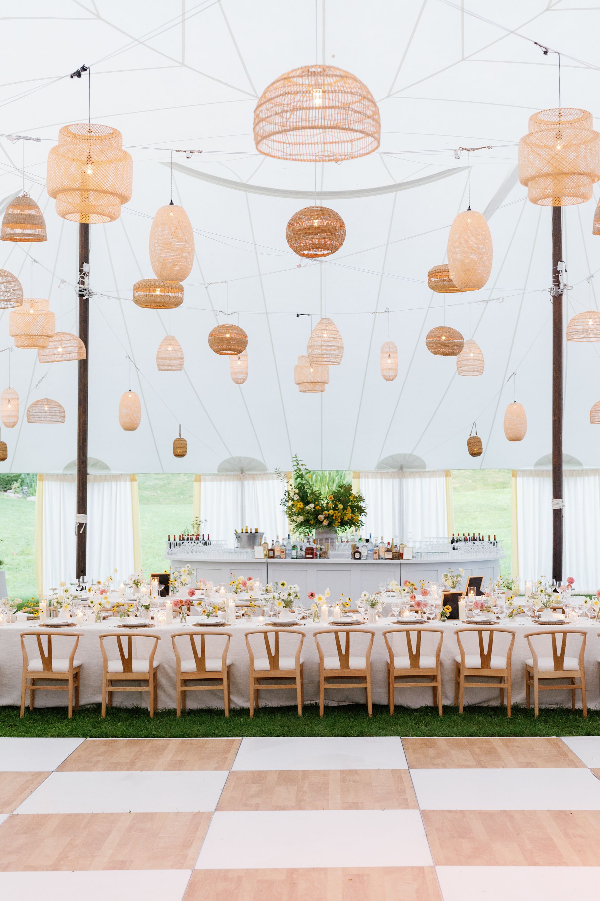 A large tent with tables and chairs and a dance floor.